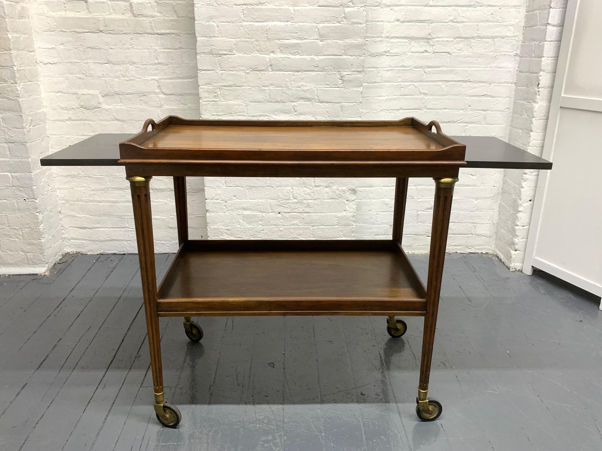 Rosewood and brass two-tier bar cart. Trolley cart has two extension side leaves with laminated tops.
Mid-Century Modern.
 