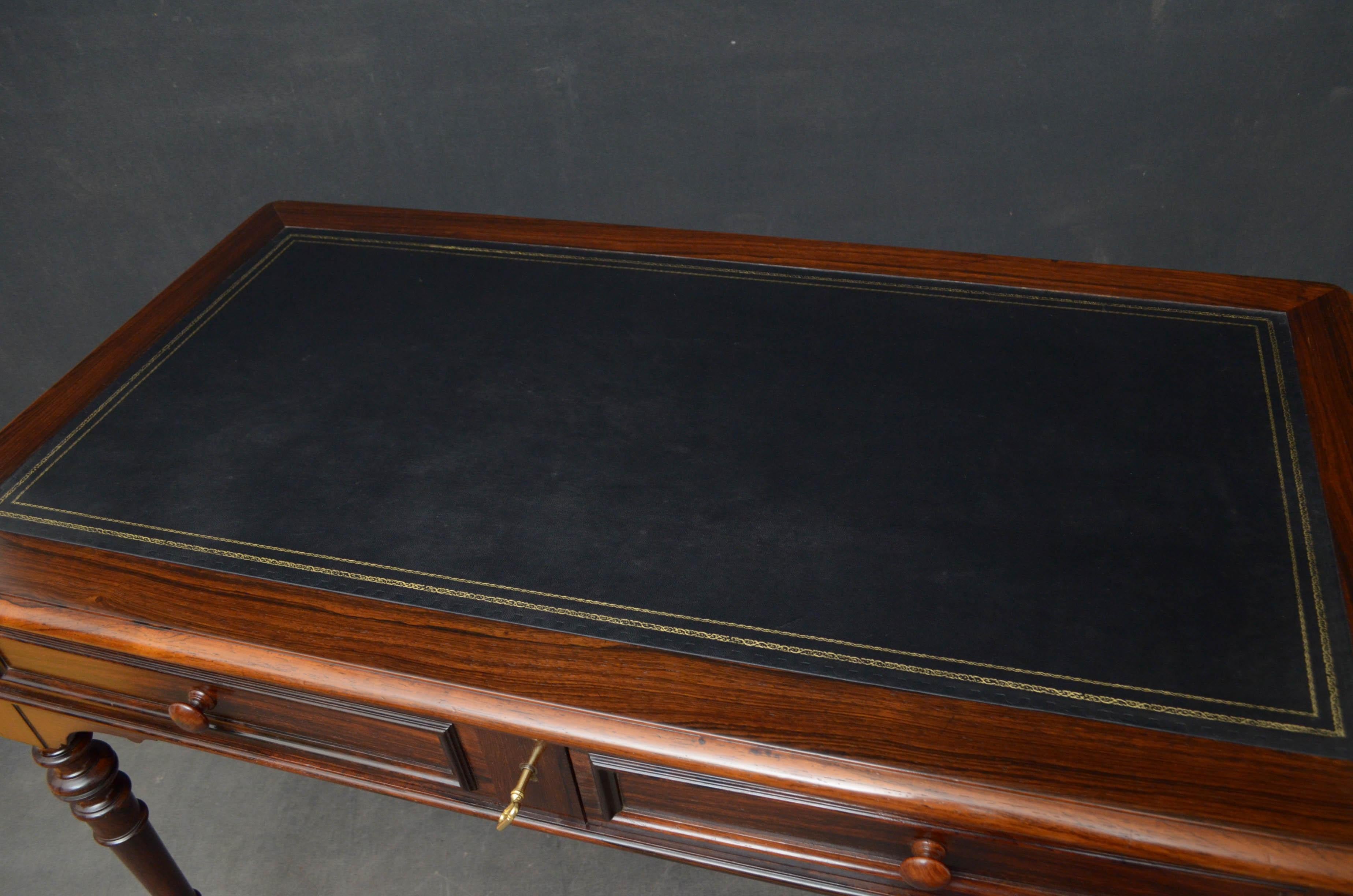 Sn4691, a very elegant French writing table in rosewood, having black tooled leather top and 2 moulded mahogany lined drawers fitted with original working lock and key, standing on slender turned legs terminating in original brass castors, all in