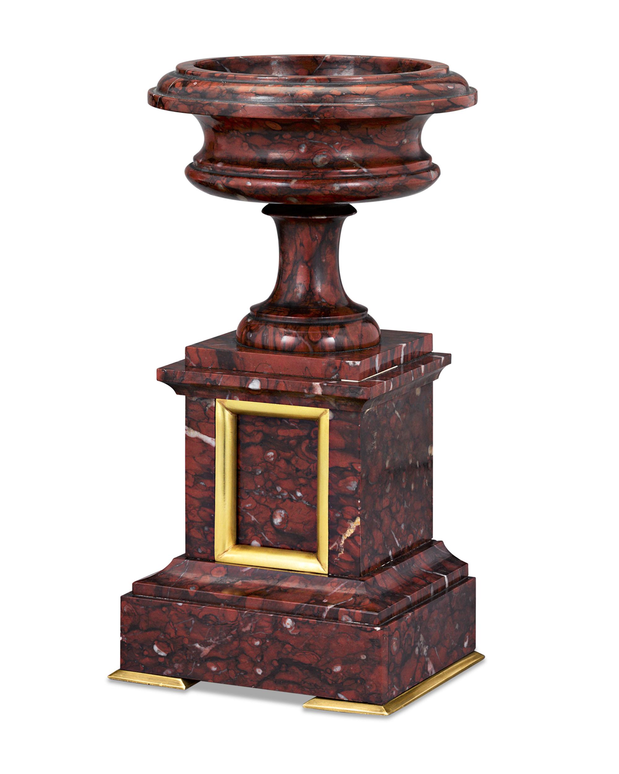 Elegant and stately is this pair of marble and doré bronze urns hewn from the finest French “Partridge eye” rouge griotte marble from the Languedoc region. Named for the griotte cherry for its deep, rich color, red griotte was the favorite marble