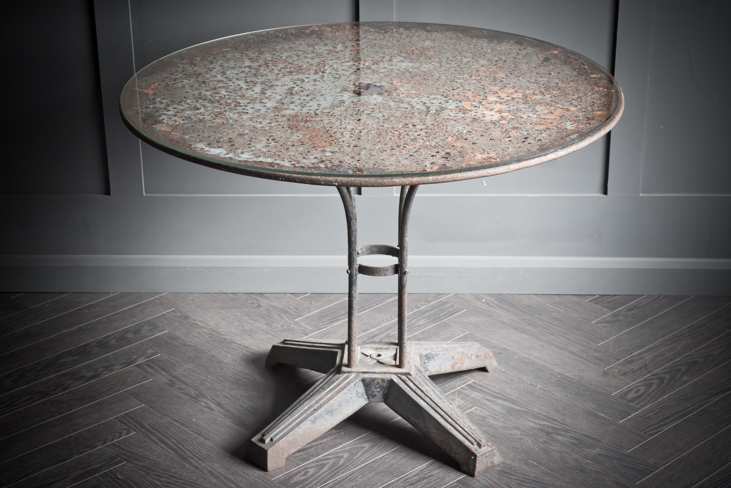 Round bistro table with glass top originating from France.