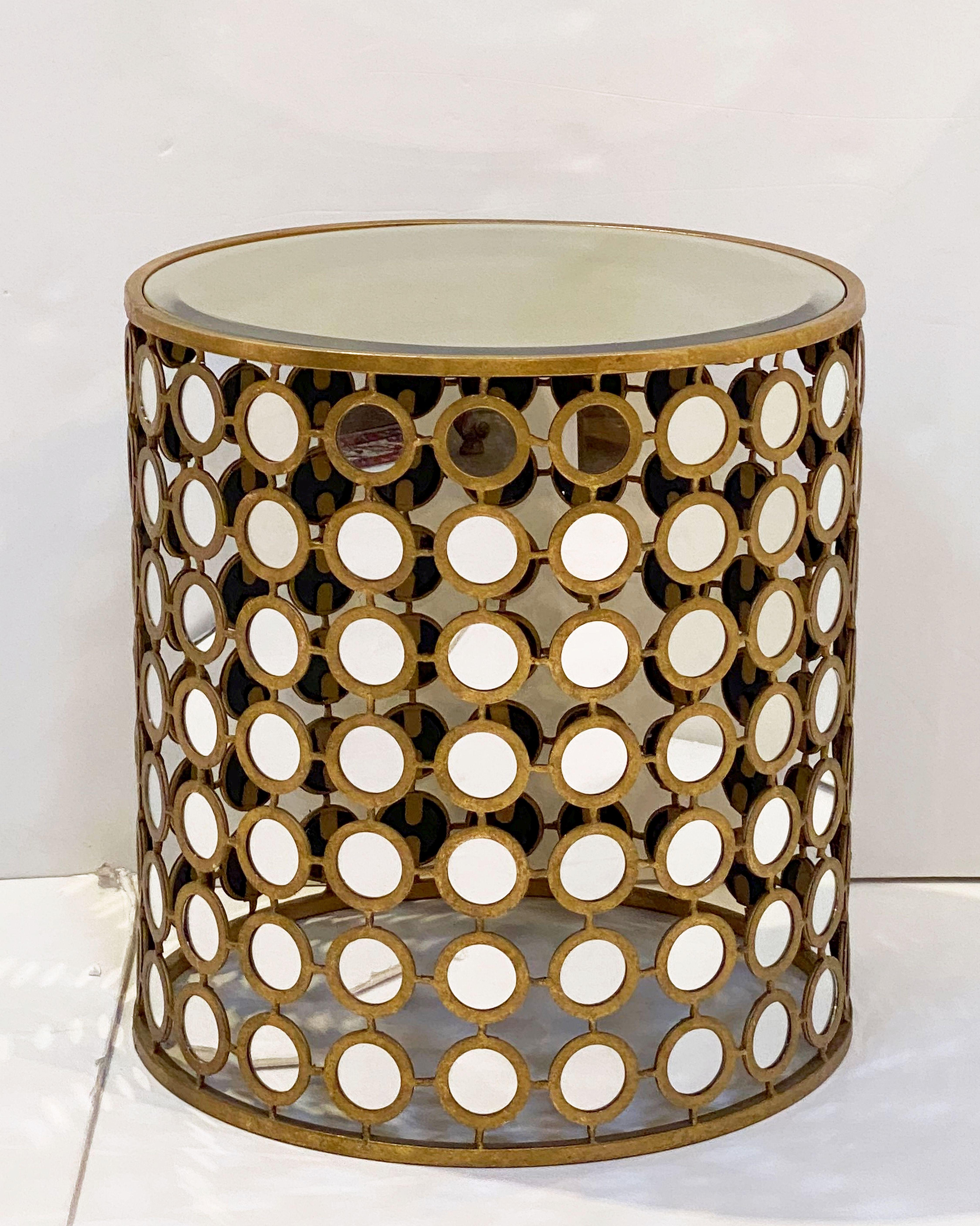 A fine French round (or barrel shaped) side or end table, featuring a circular beveled gold-tinted mirrored glass over a gilt metal base of small round mirrors in a stylish grid around the circumference.



 
