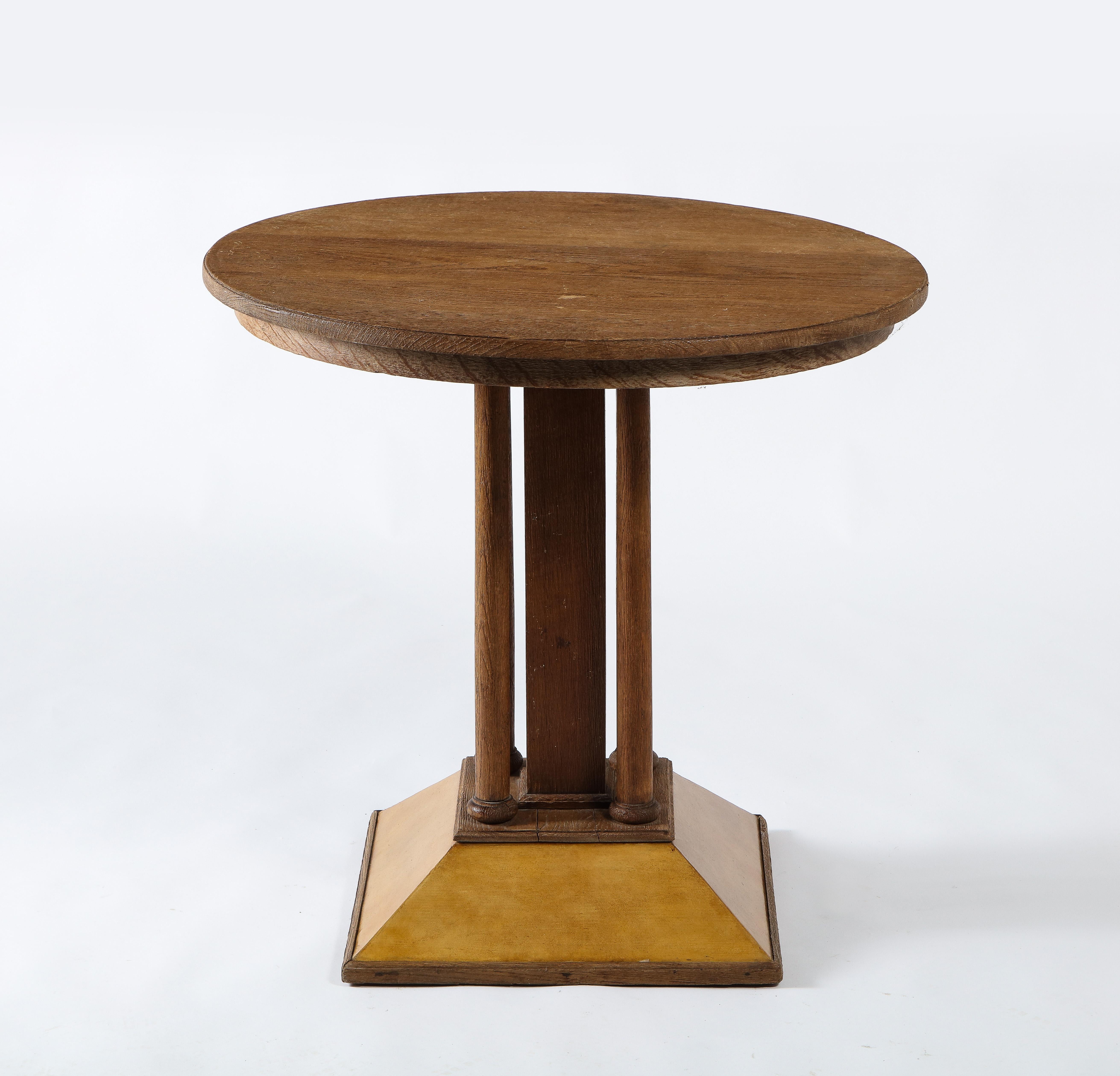 Elegant French oak and parchment gueridon in the Viennese secession style. an interesting blend of JMF touches, parchment, raw oak on a classic Viennese form with round top, 5 pillars base ending in a square pyramidal base clad in parchment. In its