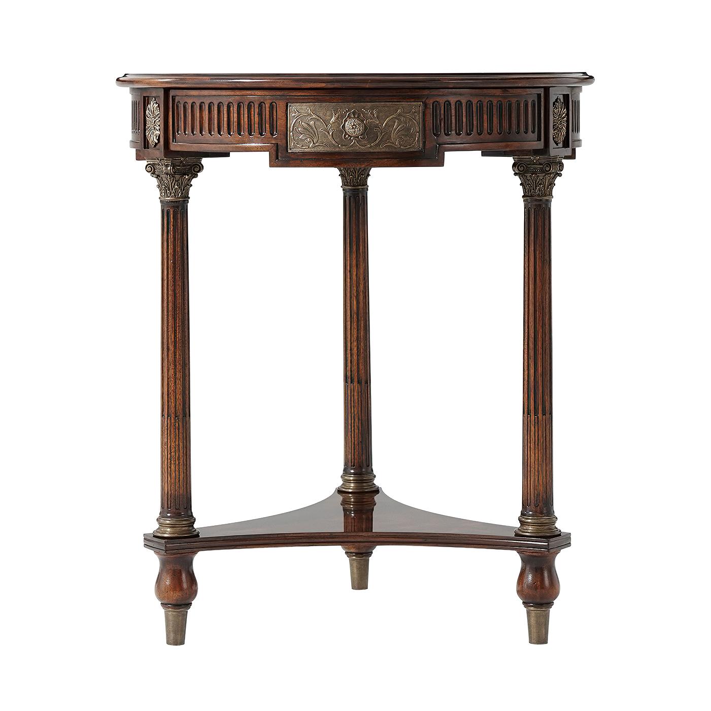 A French mahogany veneer and mahogany lamp table, the circular top above a fluted frieze and a hand worked 'bronzed' repousse panel drawer, on Corinthian capital and turned fluted legs joined by a concave sided trefoil undertier, on turned feet.