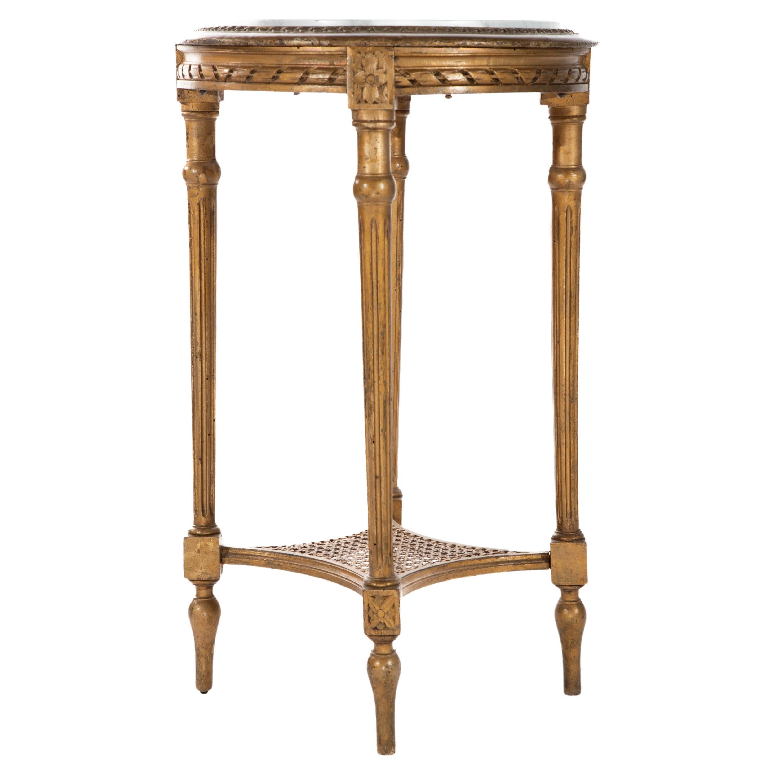 Beautiful French carved and gilt Louis XVI-style side table with inset marble top and lower caned shelf.