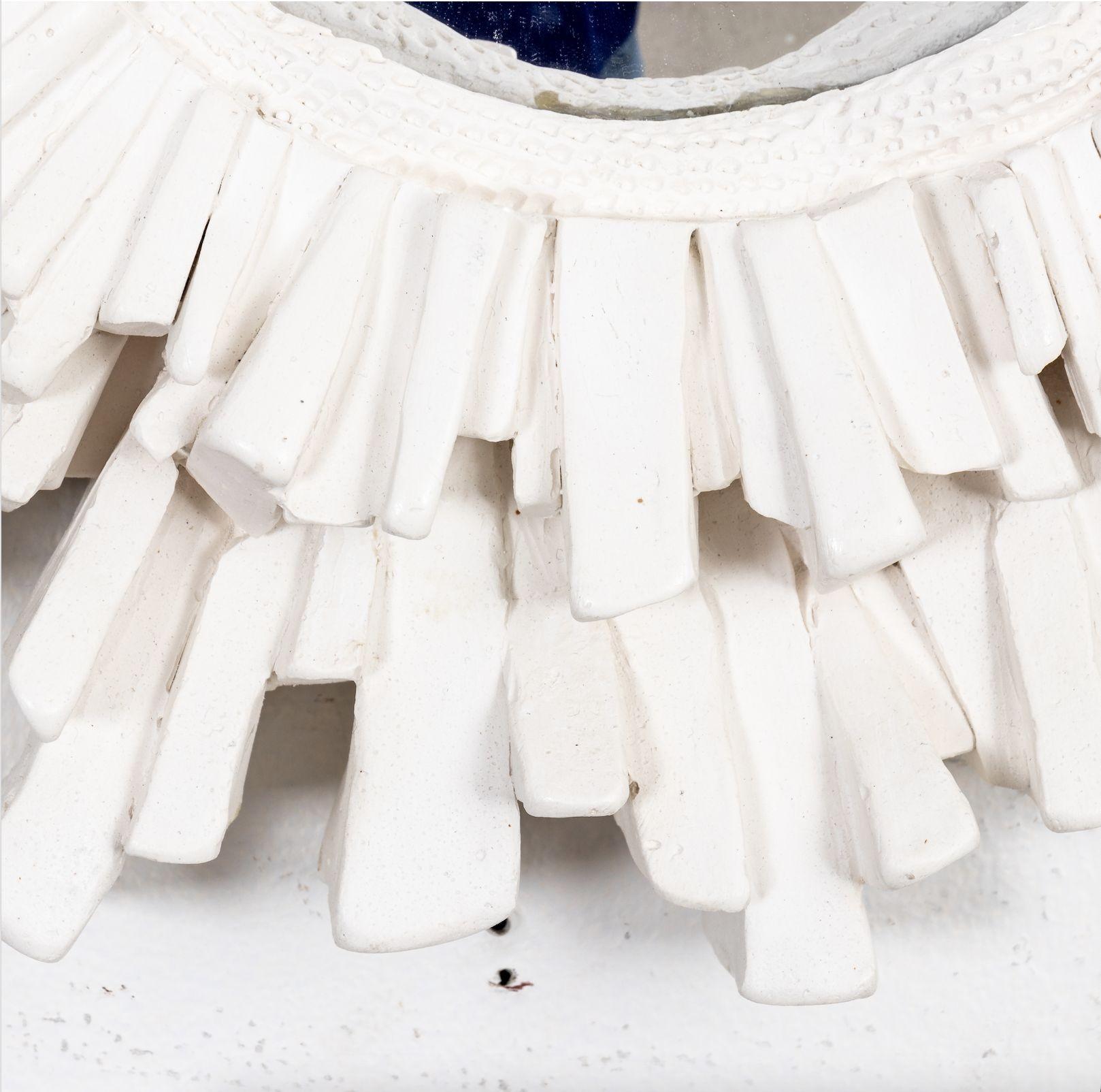 Circa 2020 Contemporary made French plaster starburst shaped mirror with round mirror plate. The frame features various lengths of layered starburst rays. Made in France. Please note of wear consistent with age.