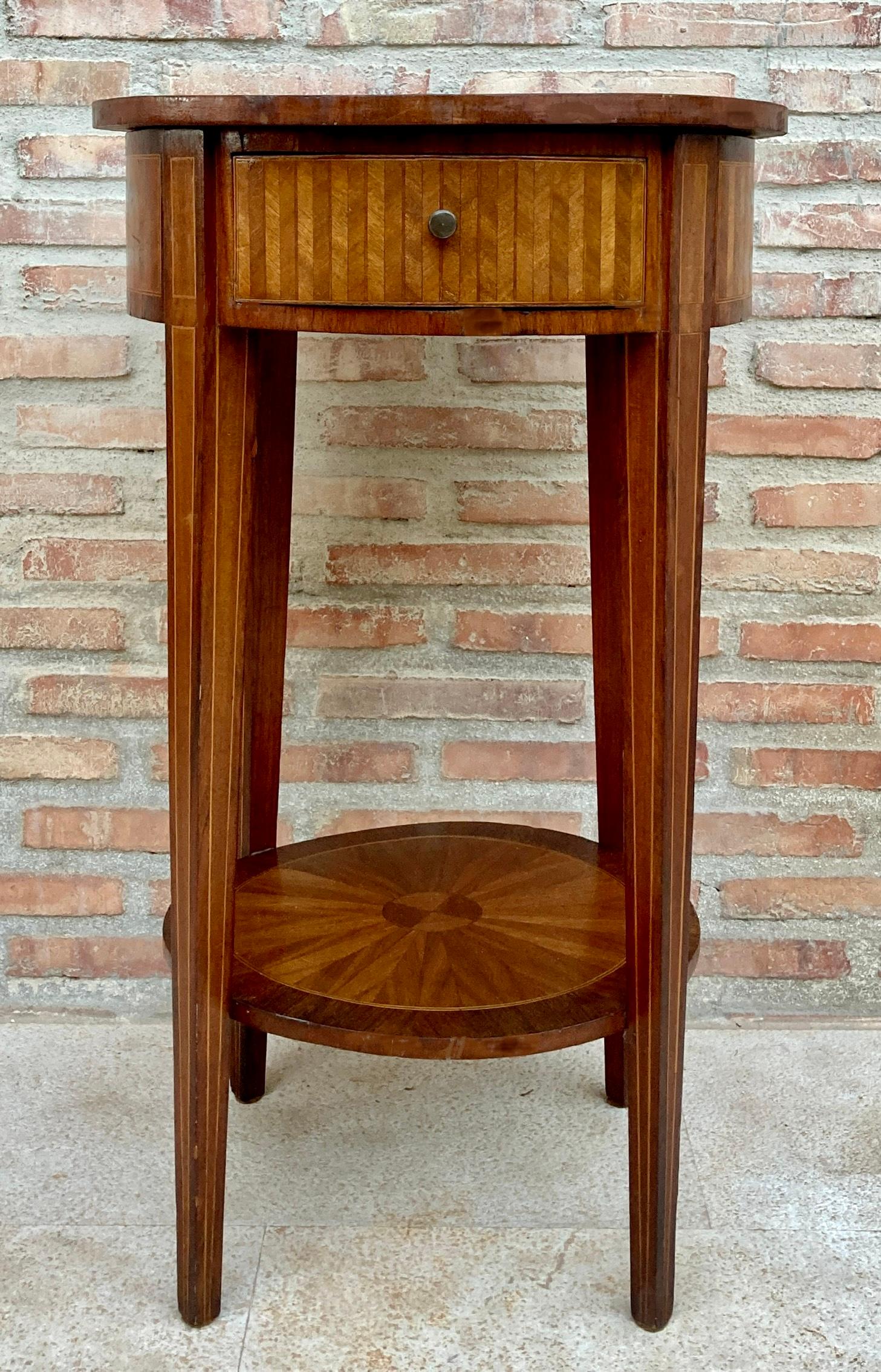 Side table mid century style with beautiful marquetry. Its elegant rounded shape makes it a particularly decorative piece for any corner of our home. 
Its four long and stylized legs serve as a support for a top with precious marquetry and a