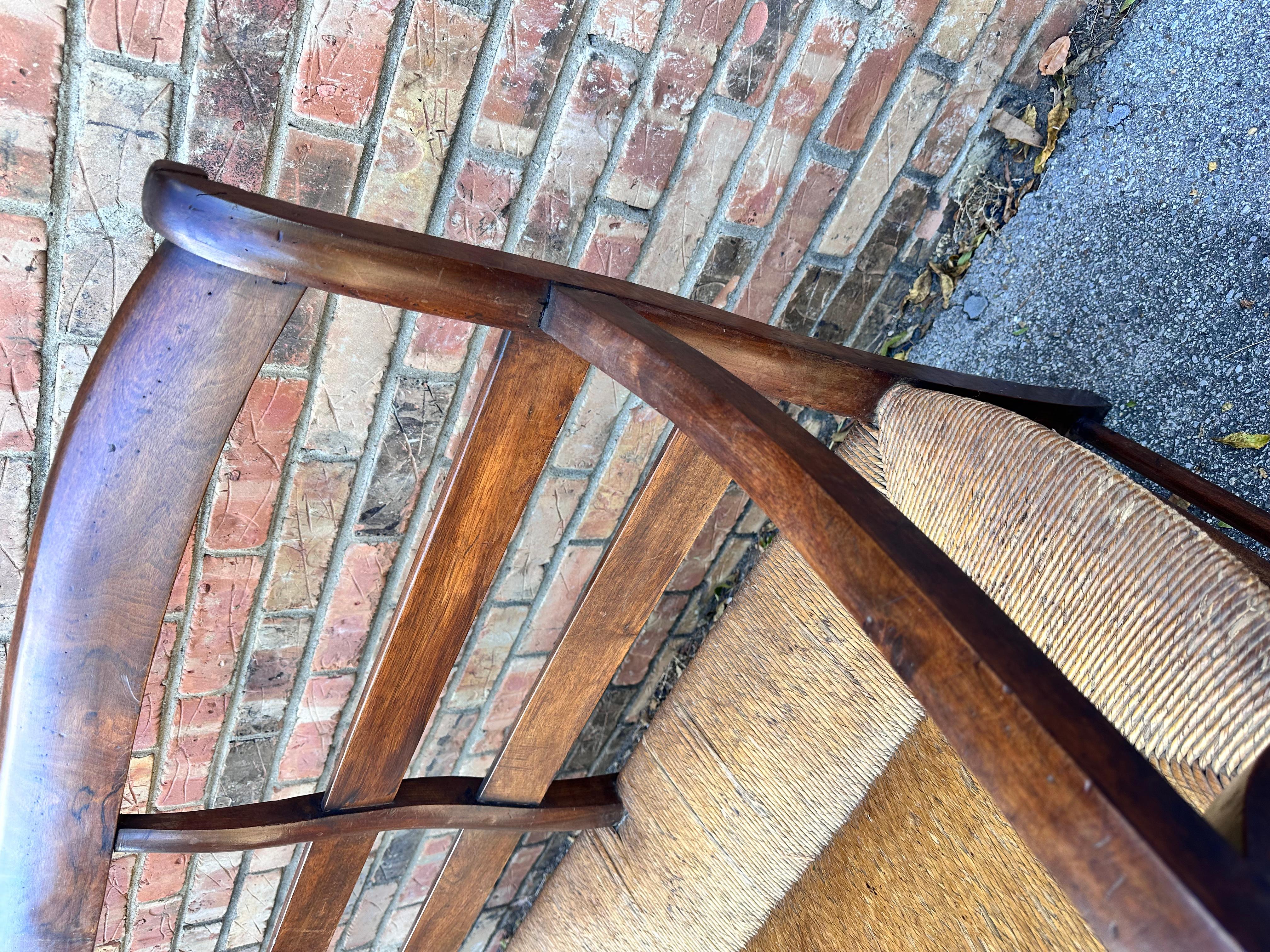 This is an absolutely beautiful French bench! Antique, and yet still in excellent condition with extra glow in the years of developed patina. This piece has gentle curves that are subtle yet elegant. The dark wood paired with the lighter rush seat