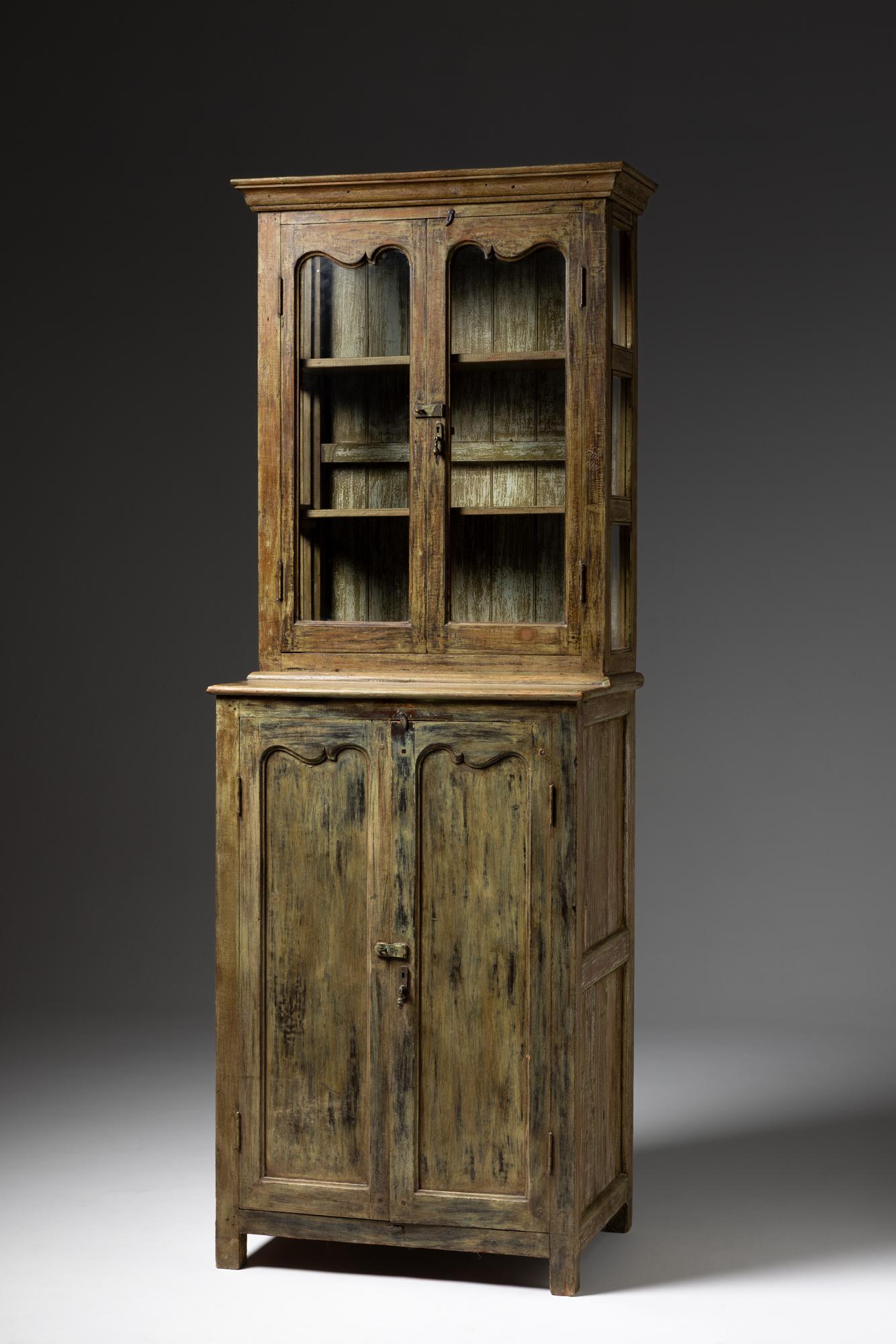 Dieser rustikale Schrank aus lackiertem Holz aus dem Frankreich des 20. Jahrhunderts ist ein charmantes Beispiel für traditionelle französische Landhausmöbel. Das Stück ist in zwei Bereiche unterteilt, die jeweils eine praktische und ästhetische