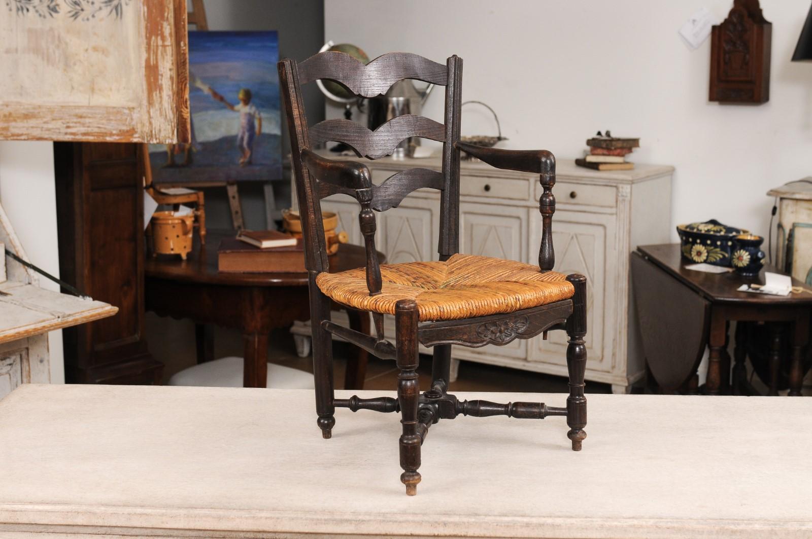 Carved French Rustic Dark Oak 19th Century Child's Chair with Ladder Back and Rush Seat For Sale