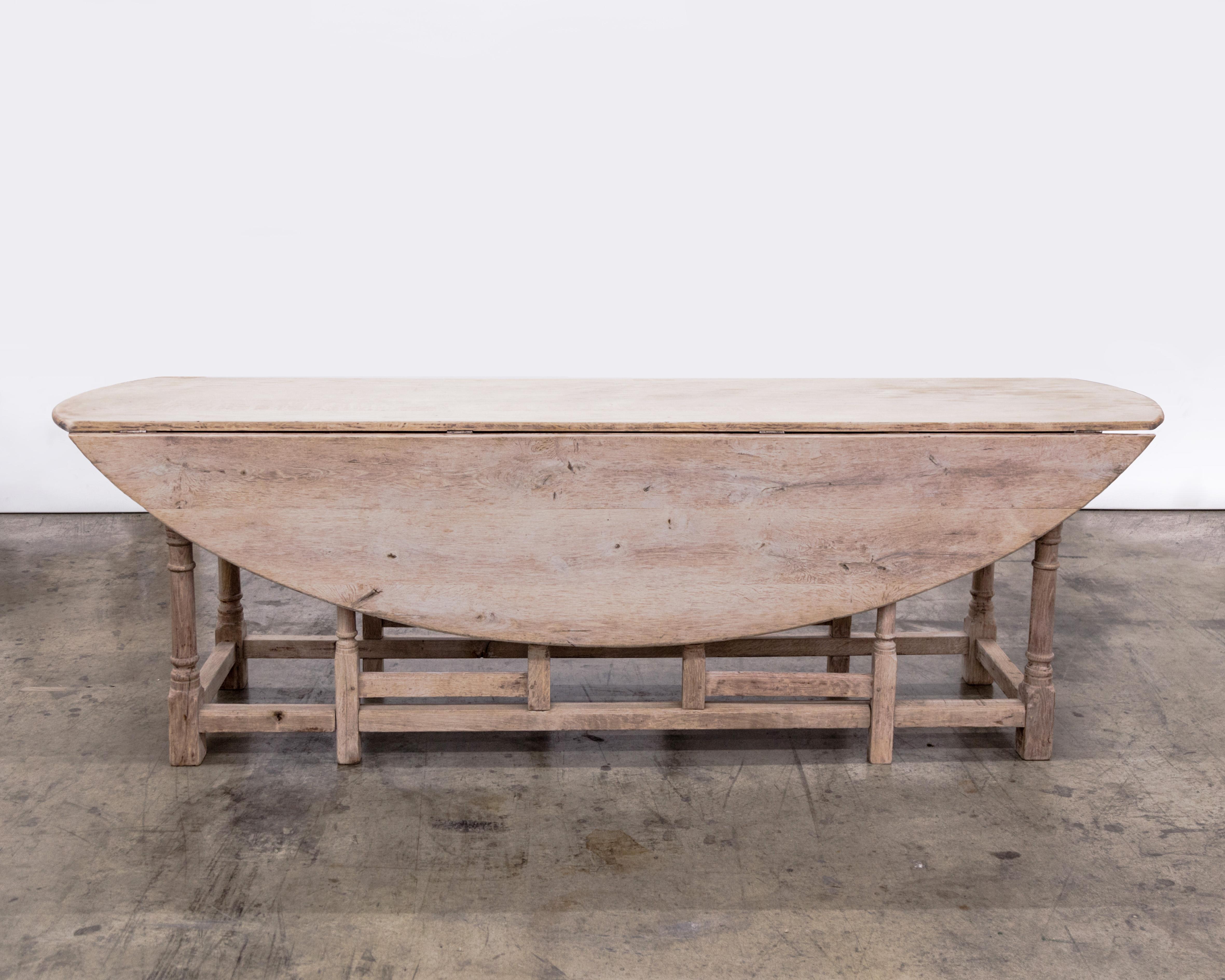 Rustic oak gate leg oval dining table with two drop leaves and turned balustrade legs. France circa 1940's.