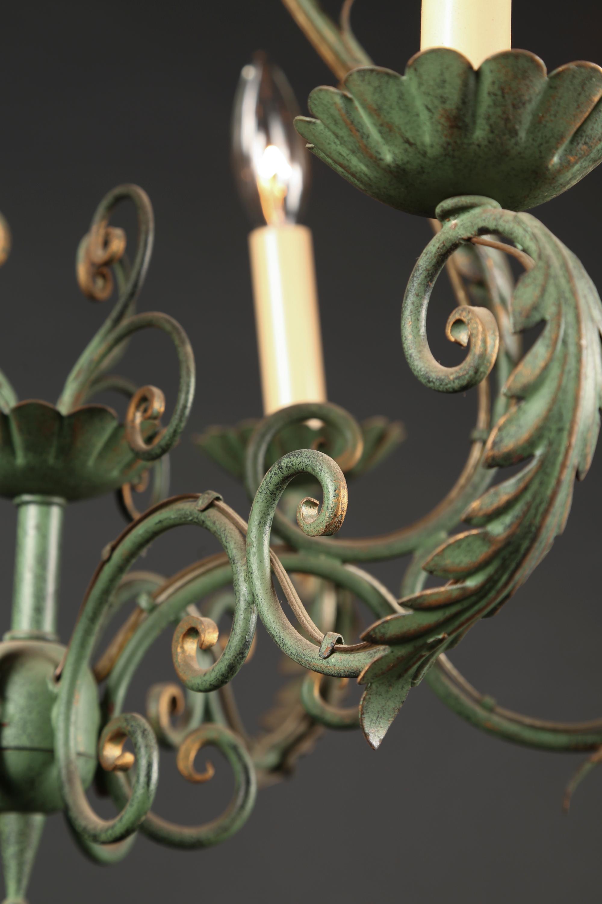 This French Louis XV style wrought iron chandeliers was created in the mid 20th century and features iron bobeches under the six lights. The arms are adorned with acanthus leaves and scroll work can be found throughout the classic ‘bird cage’ shaped