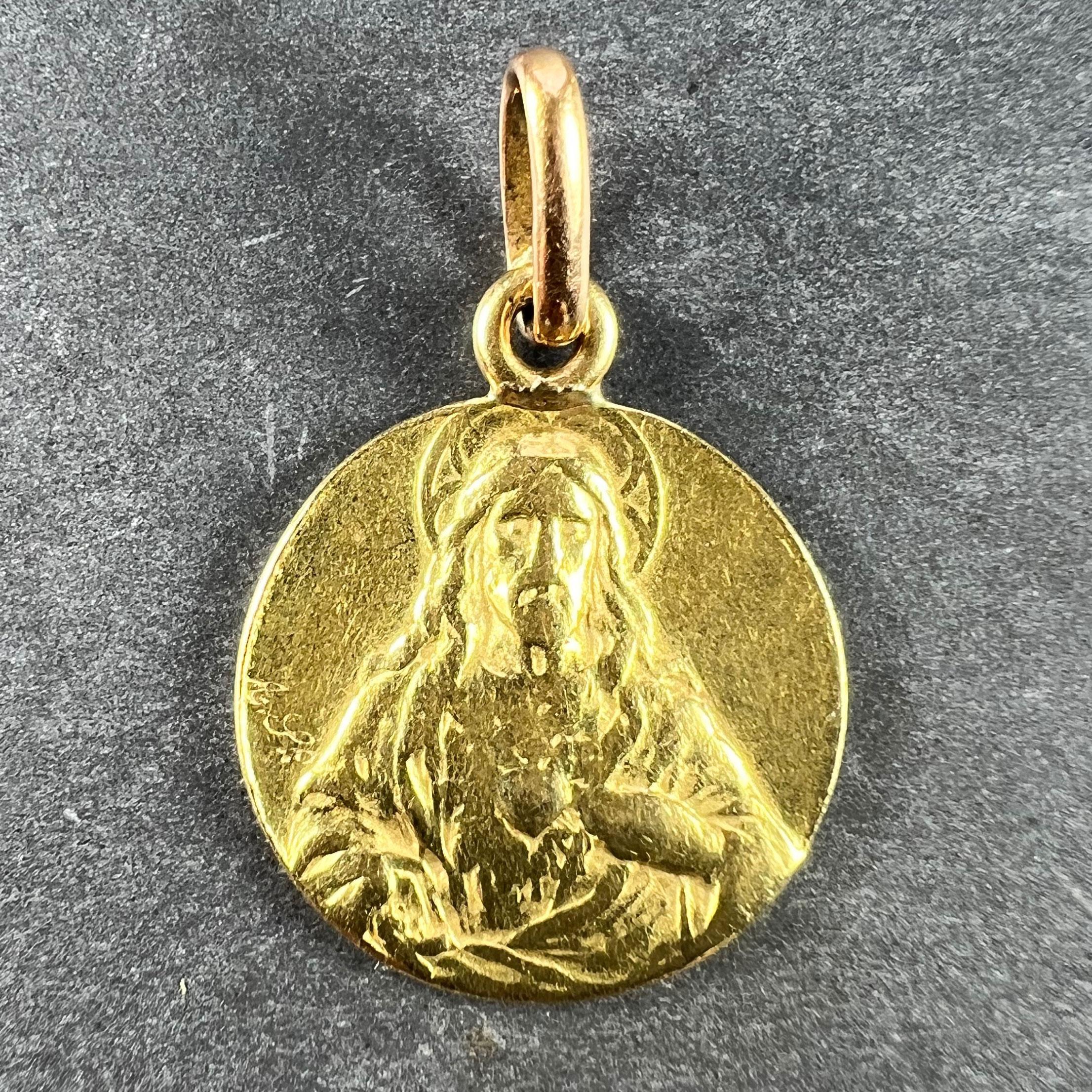 Pendentif à breloques en or jaune 18 carats (18K) conçu comme une médaille ronde avec un relief de Jésus-Christ avec le Sacré-Cœur d'un côté ; de l'autre, la Vierge Marie en Vierge à l'Enfant sur un trône au Ciel. Non marqué mais testé pour l'or 18