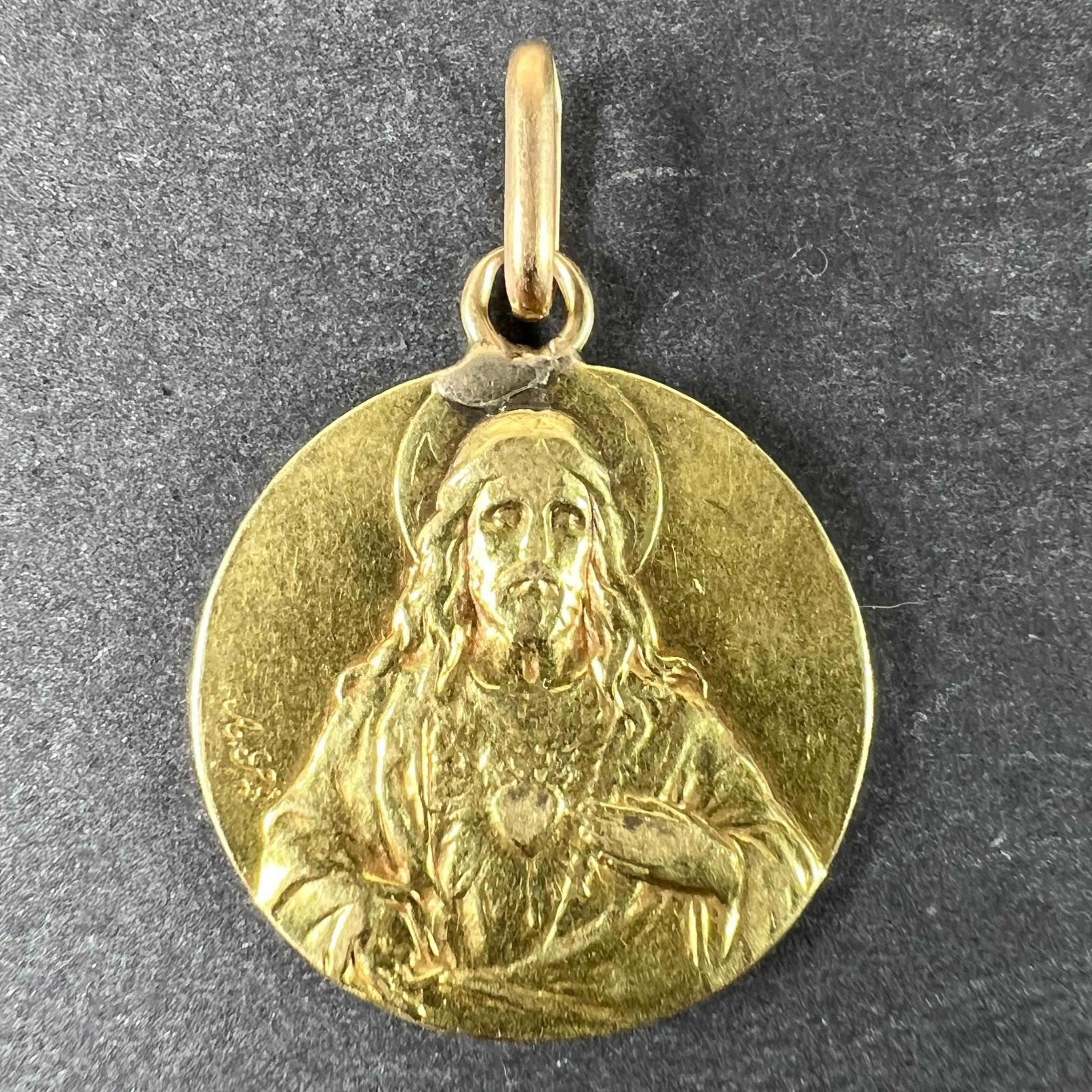 Pendentif à breloques en or jaune 18 carats (18K) conçu comme une médaille ronde avec un relief de Jésus-Christ avec le Sacré-Cœur d'un côté ; de l'autre, la Vierge Marie en Vierge à l'Enfant sur un trône au Ciel. Non marqué mais testé pour l'or 18