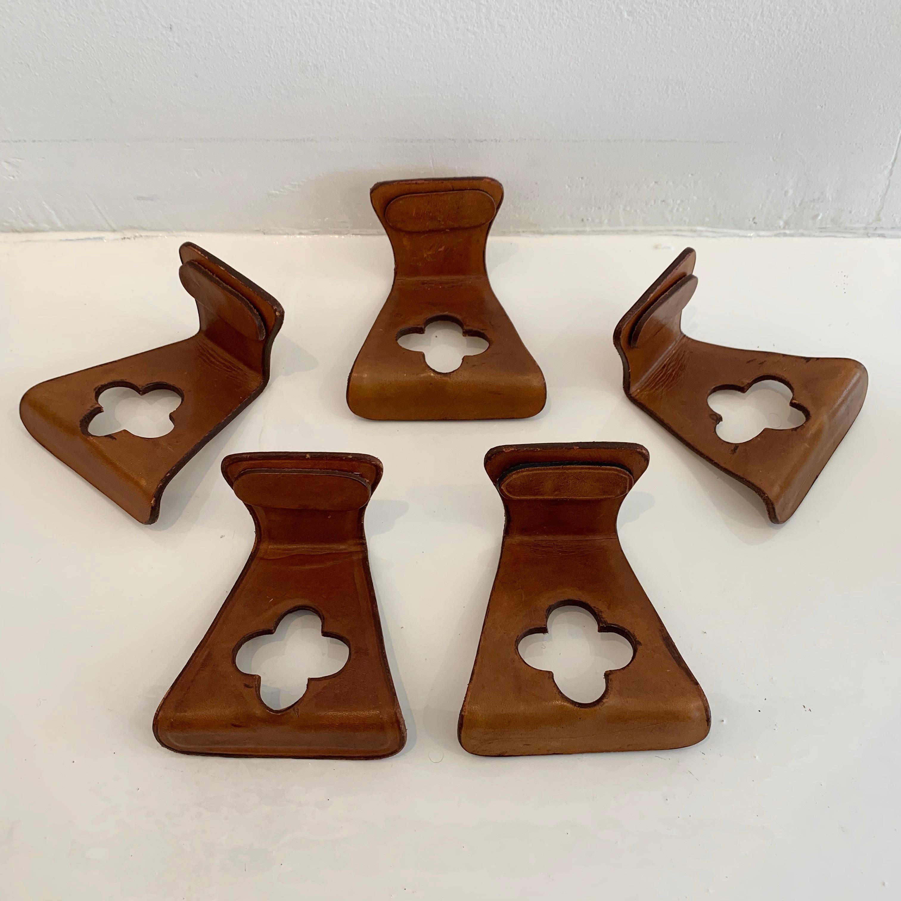Gorgeous set of French leather hooks in saddle leather. 5 available. Priced individually. Tongue shape with 4 leaf clover cutout. Super functional and unusual design. Small removable leather tab with magnetic back covers screw holes into the wall.