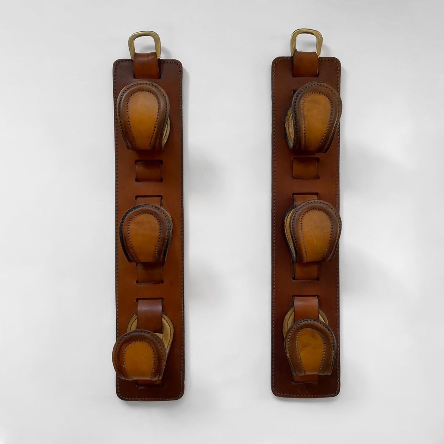 French leather wall hooks in the style of Jacques Adnet
Saddle leather triple tongue hooks on aged leather panel with contrast stitching
Aged brass ring for wall mounting
Beautiful equestrian and hunting wall storage
Patina from age and use
Priced