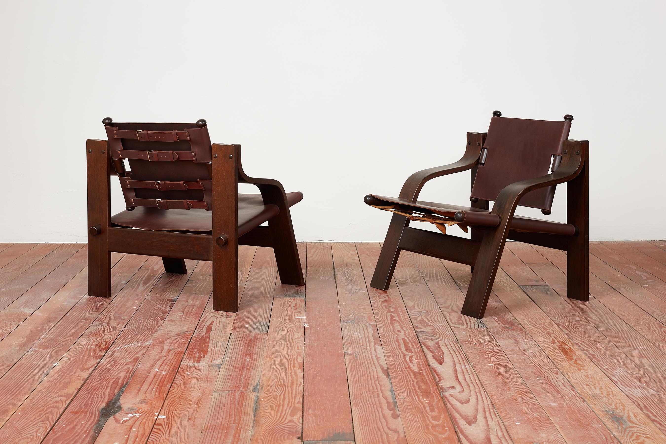 Handsome pair of French Leather Safari chairs 
Unique angular shape with deep chocolate burgundy colored leather 
Buckled detail in back - 
Professionally refinished and restored. 