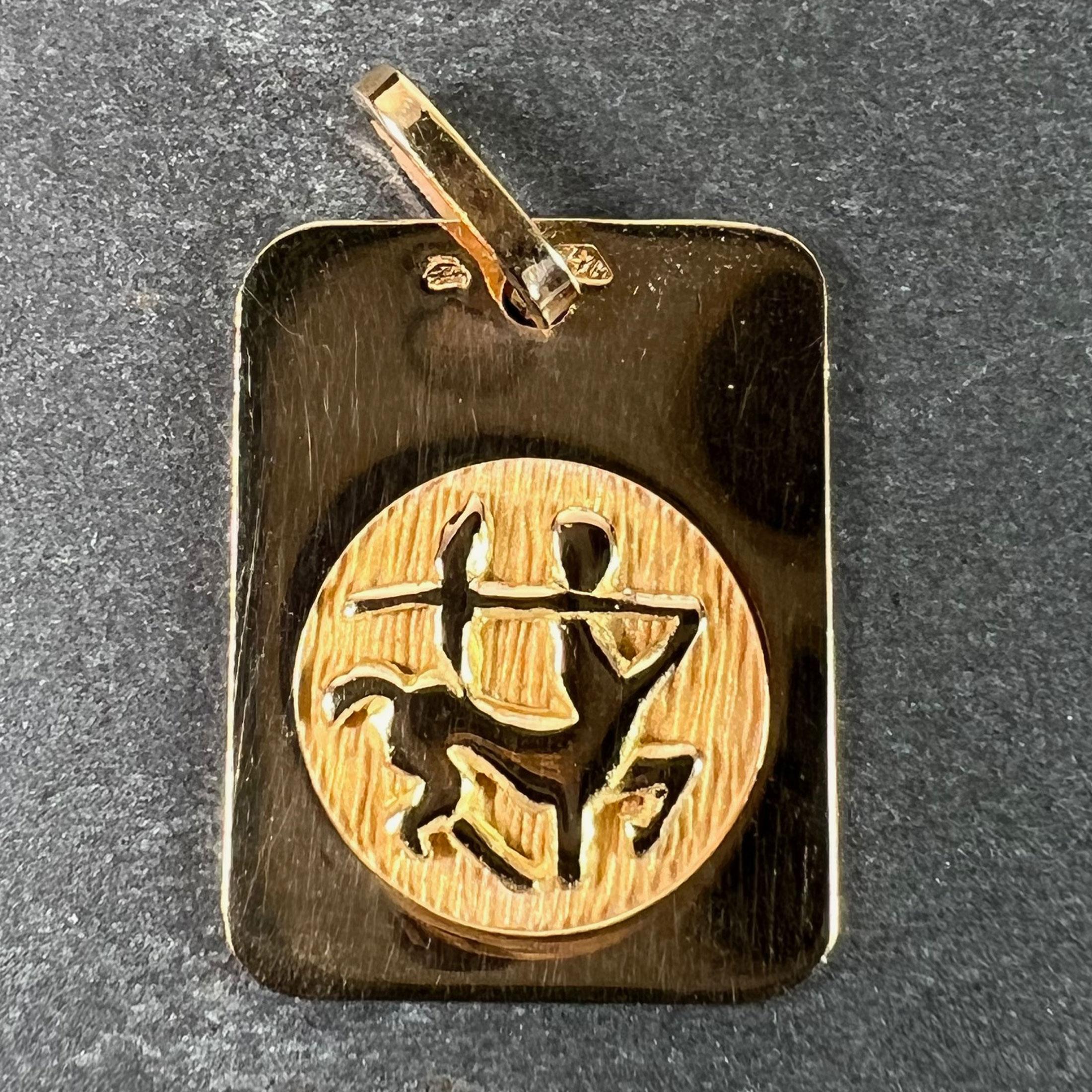 Pendentif de charme français en or jaune 18 carats (18K) conçu comme une médaille rectangulaire avec un renfoncement circulaire gravé représentant un centaure représentant le signe astrologique du zodiaque du Sagittaire. Estampillé de la tête