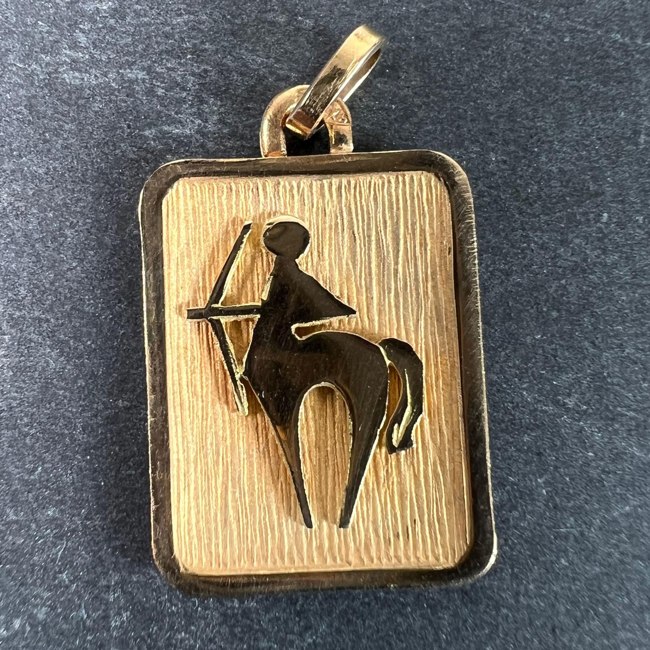 A French 18 karat (18K) yellow gold charm pendant designed as a rectangular medal with an engraved recess depicting a centaur representing the zodiac star sign of Sagittarius. Stamped with the eagle’s head for French manufacture and 18 karat gold
