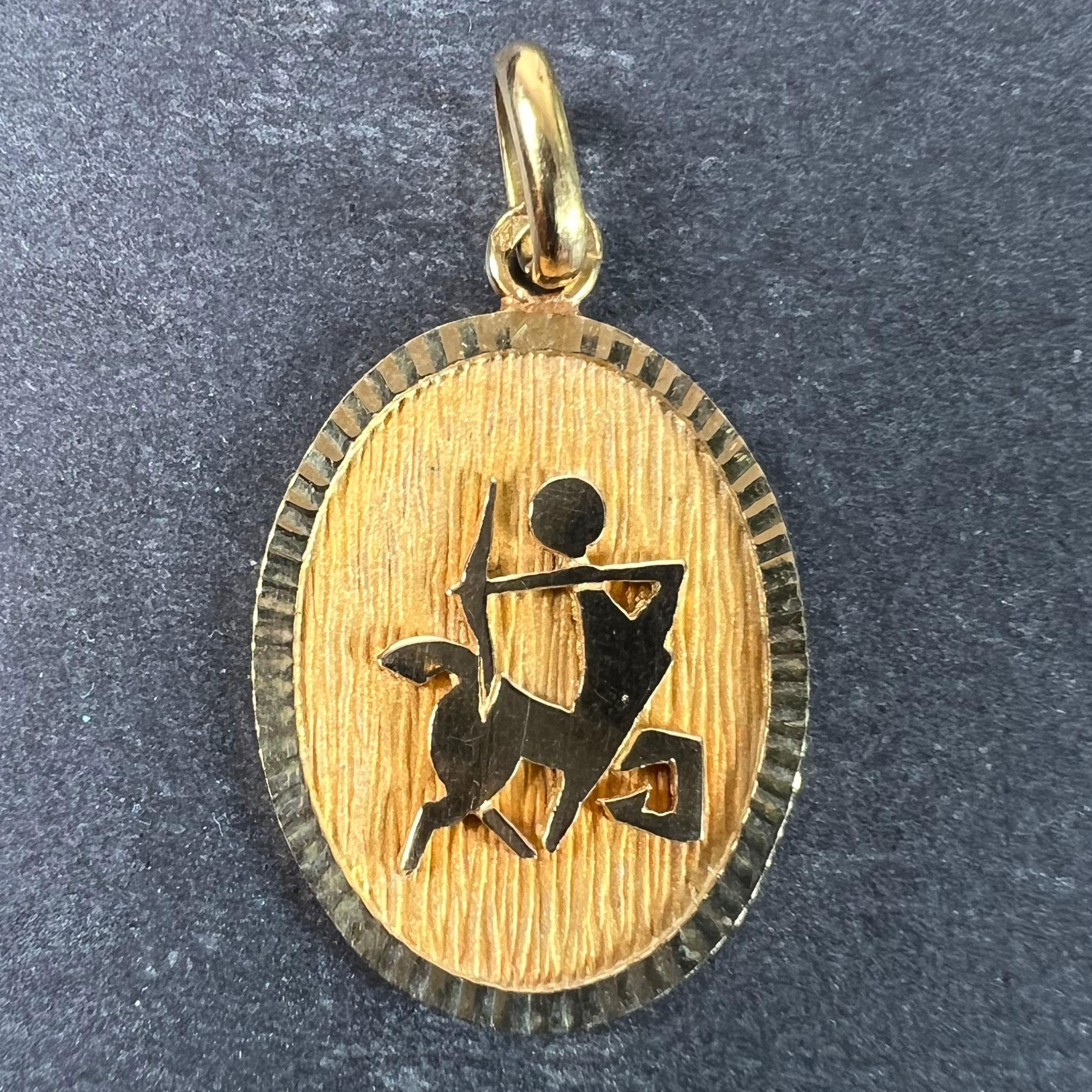 Pendentif de charme français en or jaune 18 carats (18K) conçu comme une médaille ovale avec un renfoncement mat représentant un centaure représentant le signe astrologique du zodiaque du Sagittaire. Estampillé de la tête d'aigle pour la fabrication