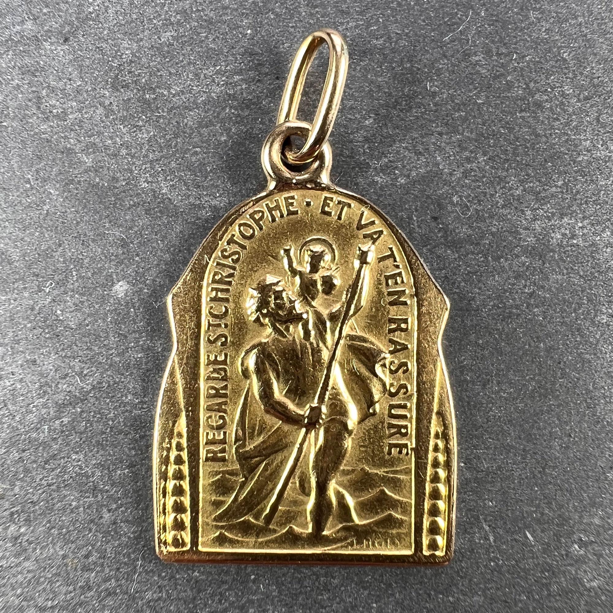 A French 18 karat (18K) yellow gold charm pendant designed as a medal depicting Saint Christopher carrying the infant Christ over a river with the motto of ‘Regarde St. Christophe et va t’en rassure’ to one side, and a depiction of the Triumph of