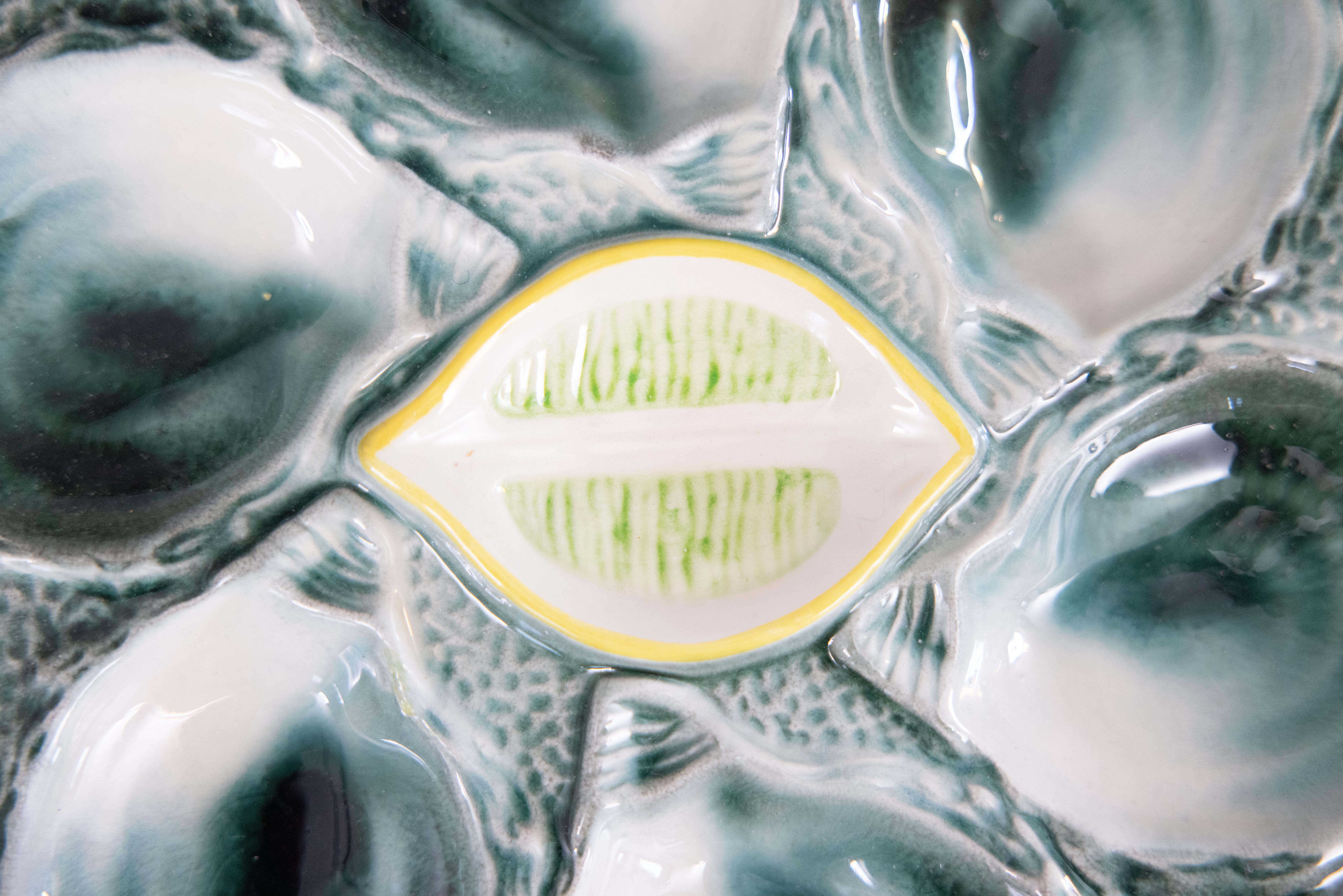 Precioso plato antiguo de mayólica francesa fabricado en la fábrica de loza St. Clement de Francia, hacia 1920-1930. Marca del fabricante en el reverso. Este magnífico plato de ostras tiene seis pocillos con brillantes colores verde azulado que