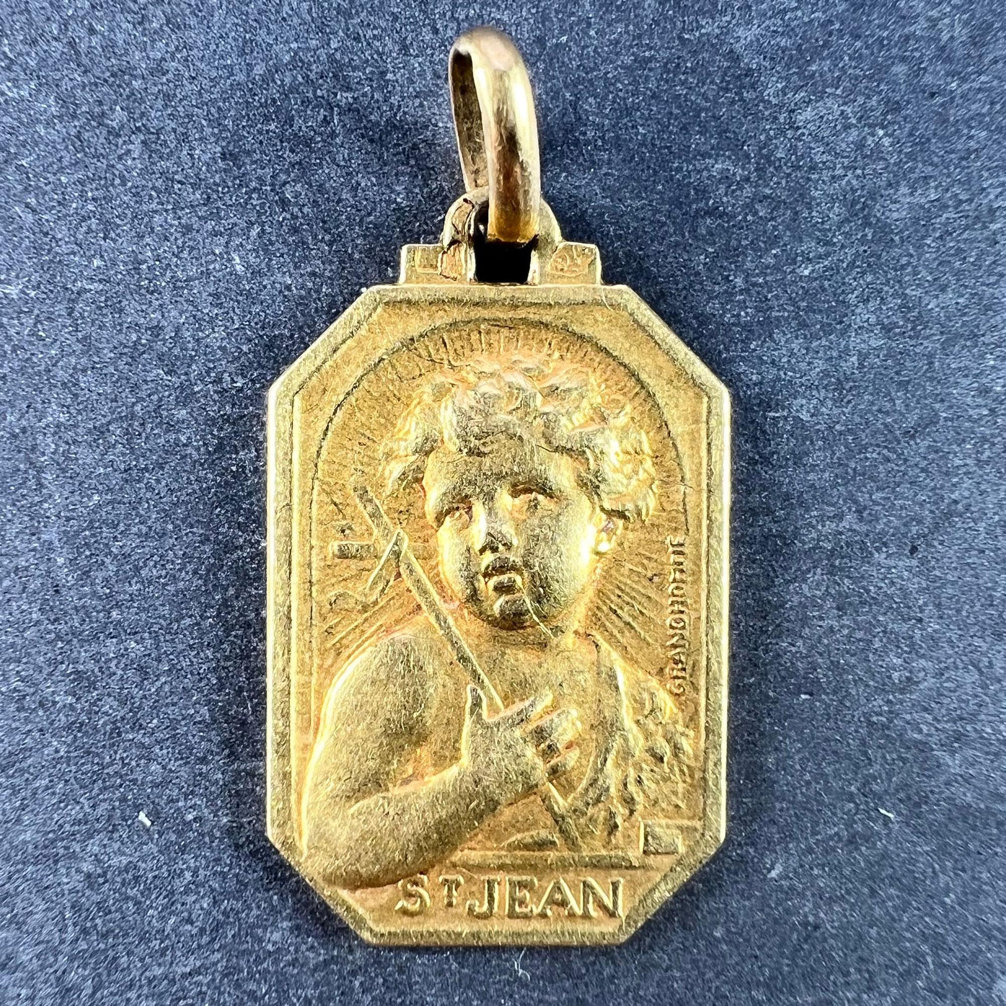 A French 18 karat (18K) yellow gold charm pendant designed as a medal representing Saint John the Baptist as a child with a lamb and a cross, with the name 'St Jean' below. Engraved to the reverse 'Jean-Pierre 11 Decembre 1942'. Signed Grandhomme,