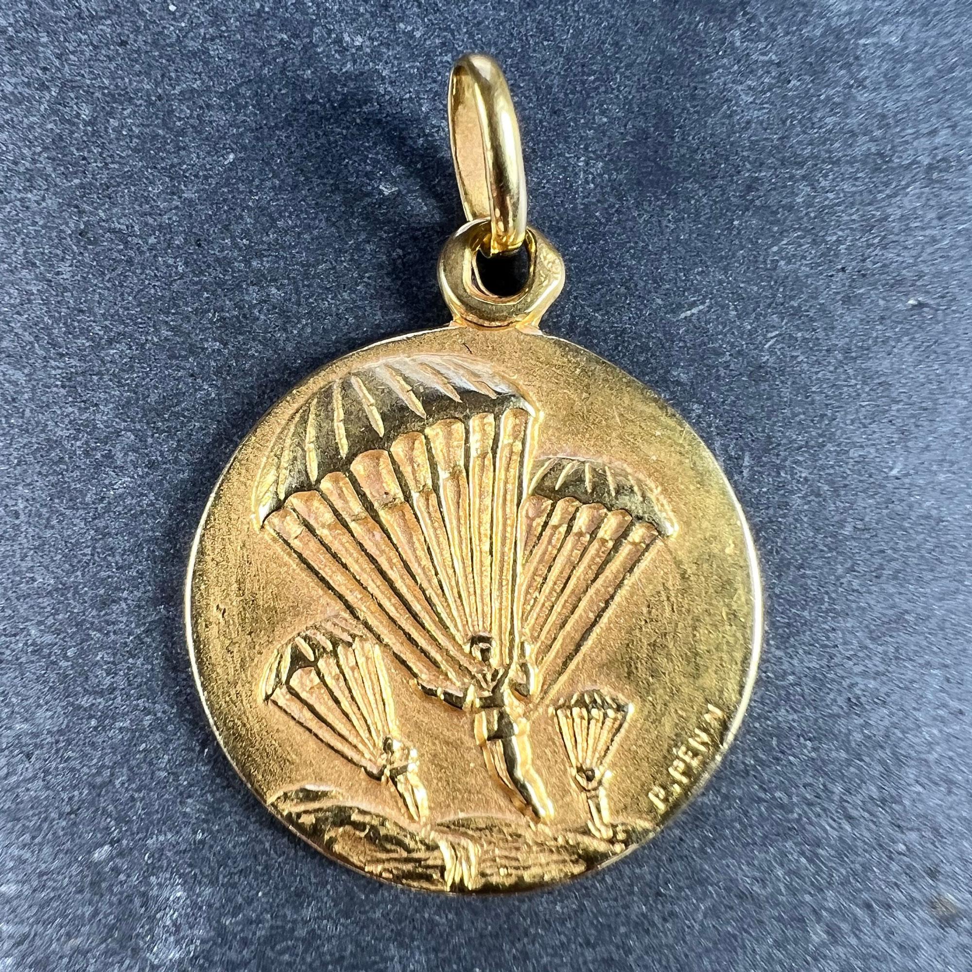 A French 18 karat (18K) yellow gold charm pendant depicting a military regiment descending on a landscape by parachute. The reverse depicts Saint Michael defeating Satan with the phrase 'S. MICHAEL ARCHANG O.P.N.' (Saint Michael Archangel watch over