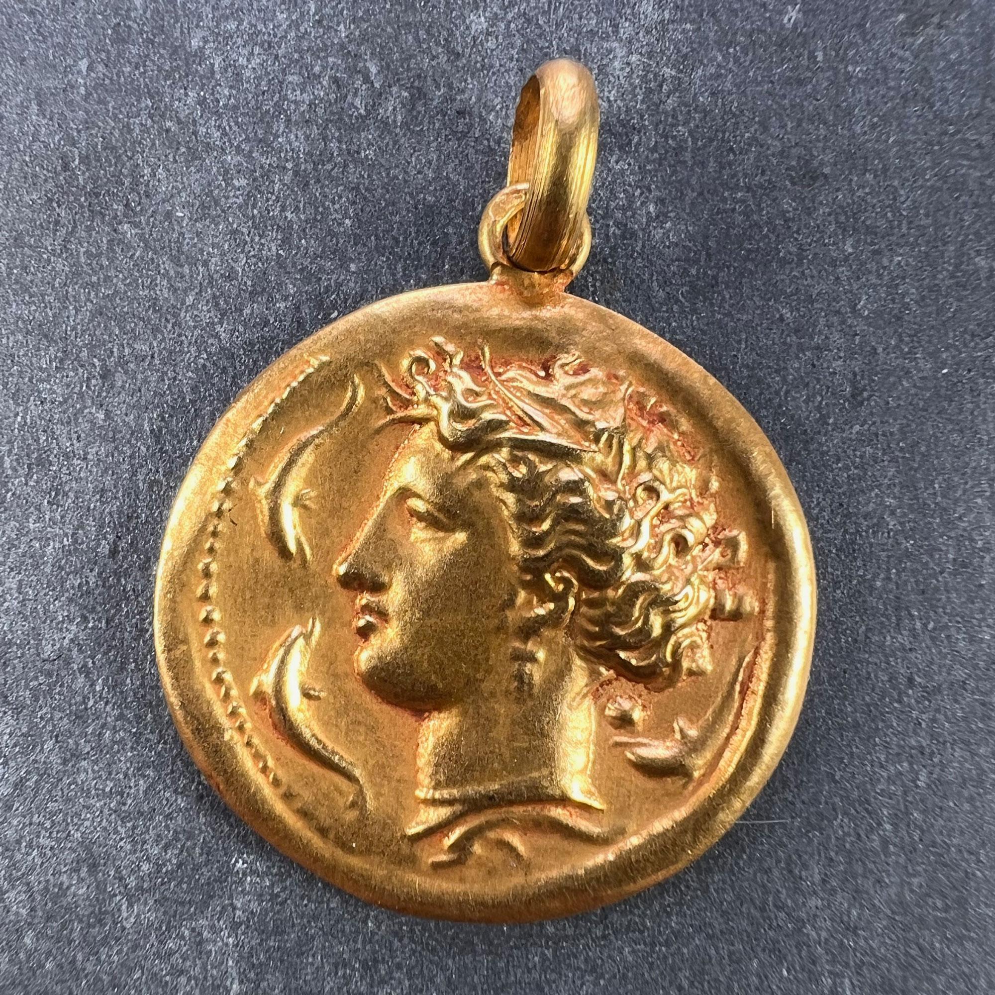 Ein französischer Anhänger aus 18 Karat (18K) Gelbgold in Form einer Medaille, die die Meeresgöttin Salacia (römisch) oder Amphitrite (griechisch) darstellt, gekrönt von Seetang und umgeben von Delphinen. Gestempelt mit der Adlerkopfmarke für
