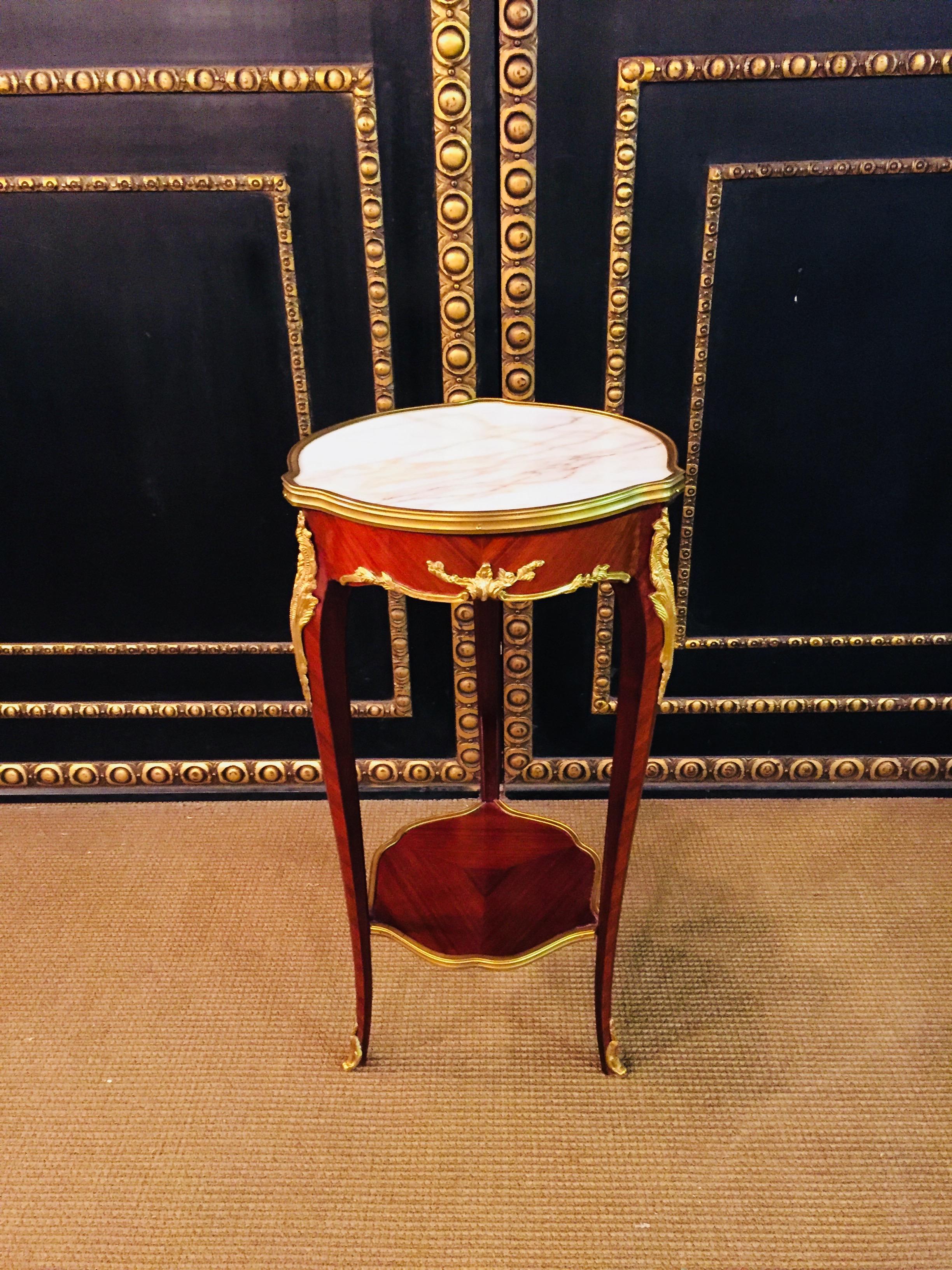 Solid wood side table in Louis XV. Slightly convex and concave, carcass, flanked by solid corner glaciers on high, elegantly curved legs, connected below by a curly brass frame framed by an intermediate shelf, ending with bronze fittings in sabots.