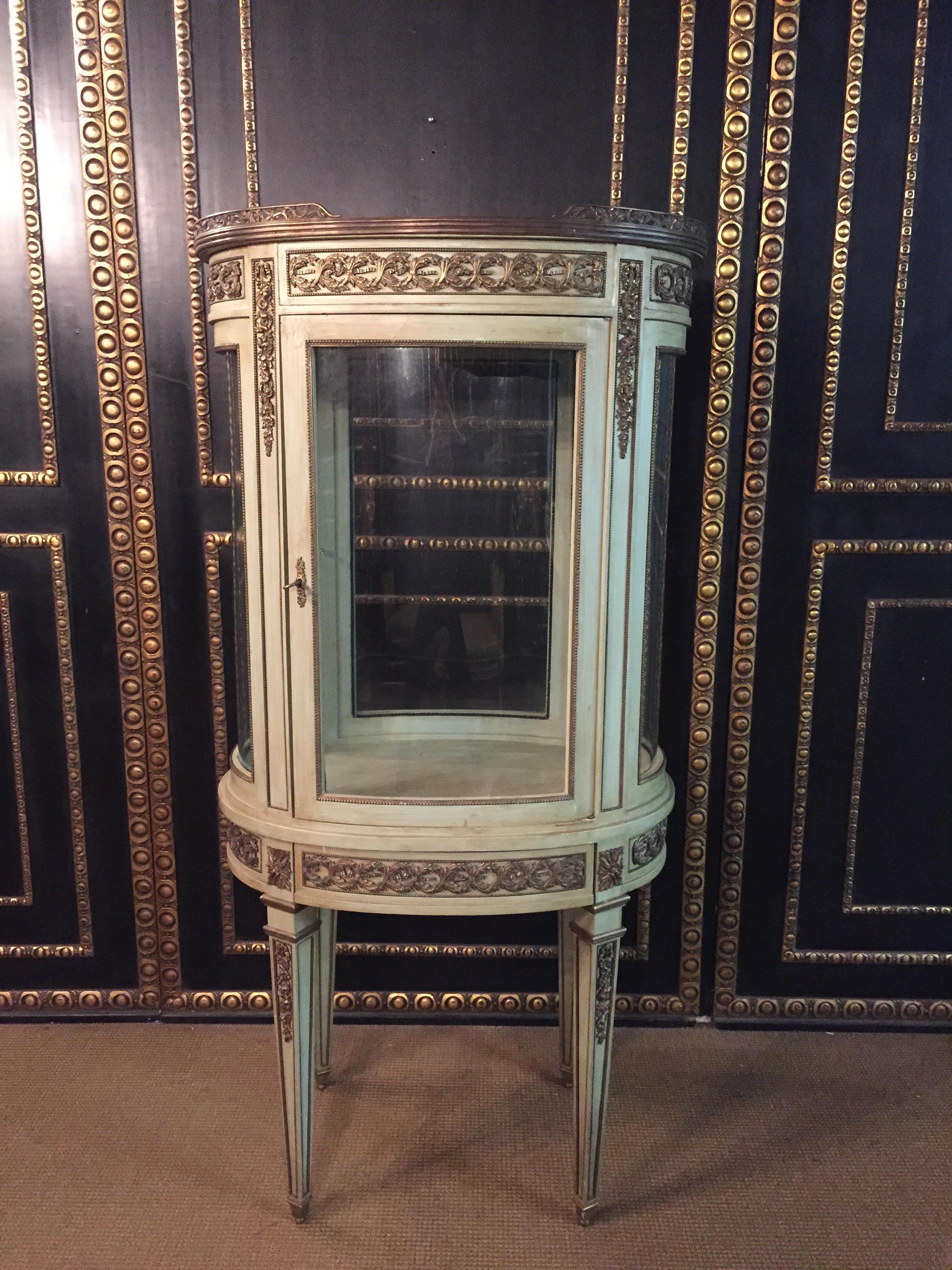 Solid beechwood colored hand painted. Oval one- drawered combered and four-sided glassed body on high, brass-painted four edged legs, ending in sabots. Border and cornicing with finely engraved classicist bronze. Fine broken-through border gallery