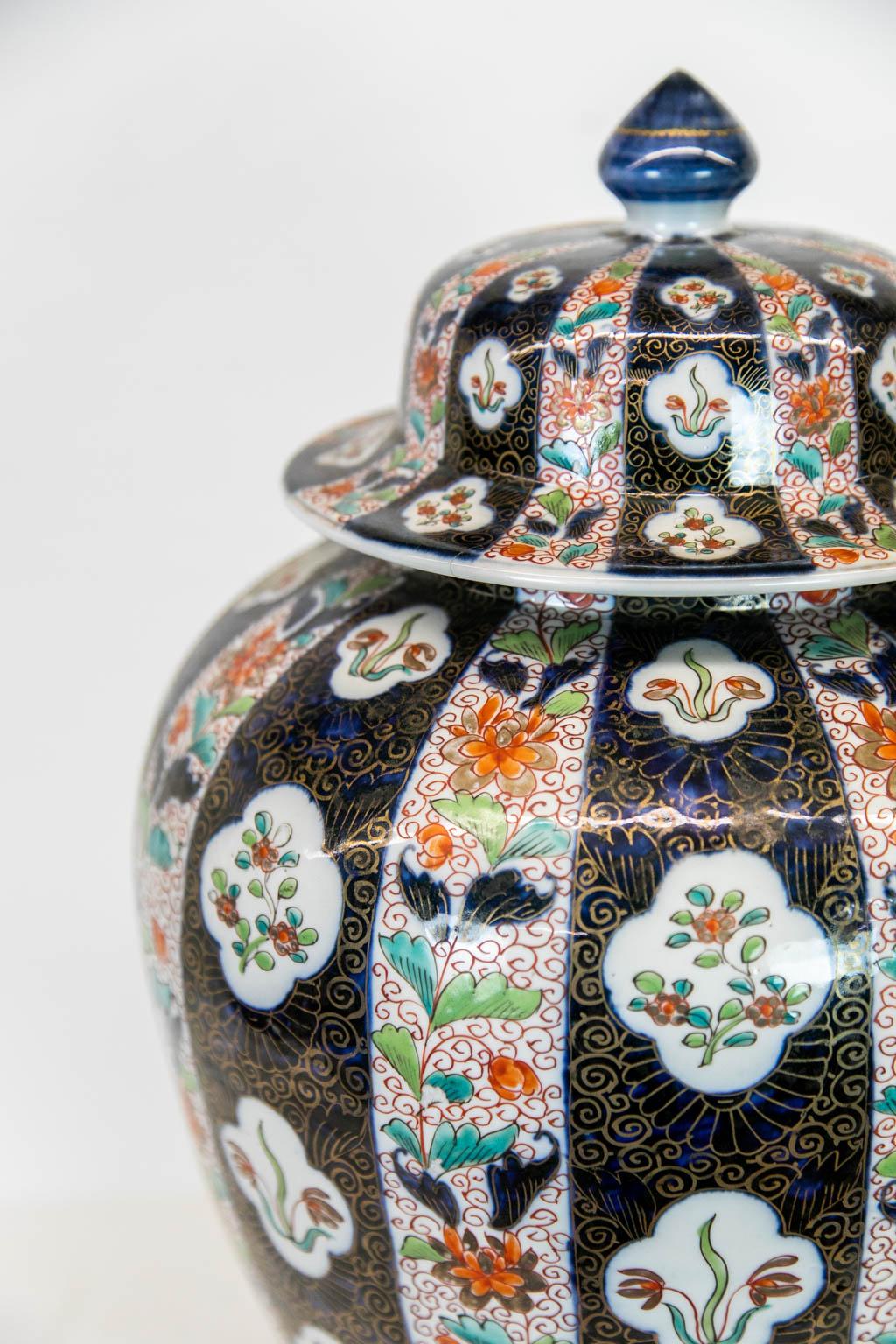 Der Deckel dieser Vase hat einen Haarriss. Die Vase ist in gutem Zustand. Sie ist mit floralen Motiven bemalt und mit vergoldeten Akzenten versehen.