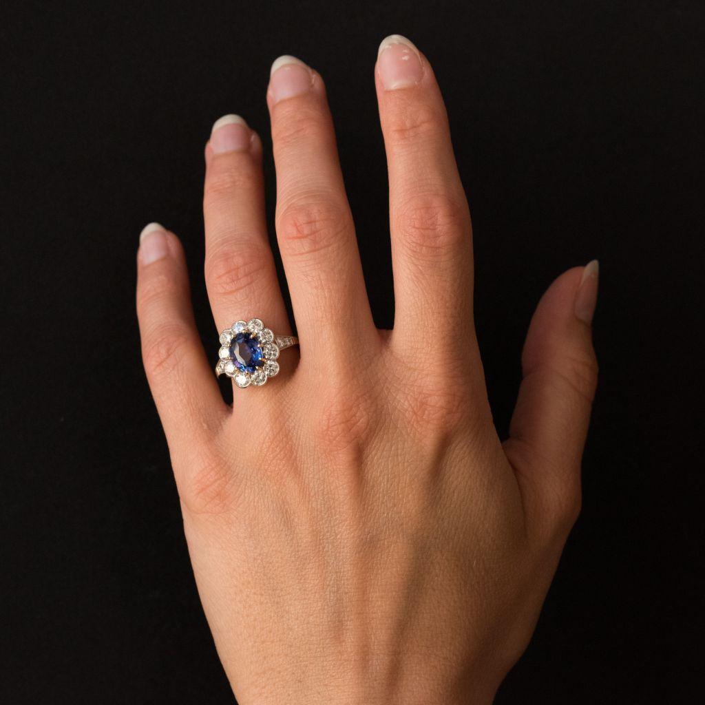 Ring in 18 karats yellow gold, and platinum, eagle's head and dog's head hallmarks.
Sublime antique style ring, the frame is adorned with an oval sapphire surrounded by 10 brilliant- cut diamonds set with millegrains. 2 x 2 decreasing diamonds are
