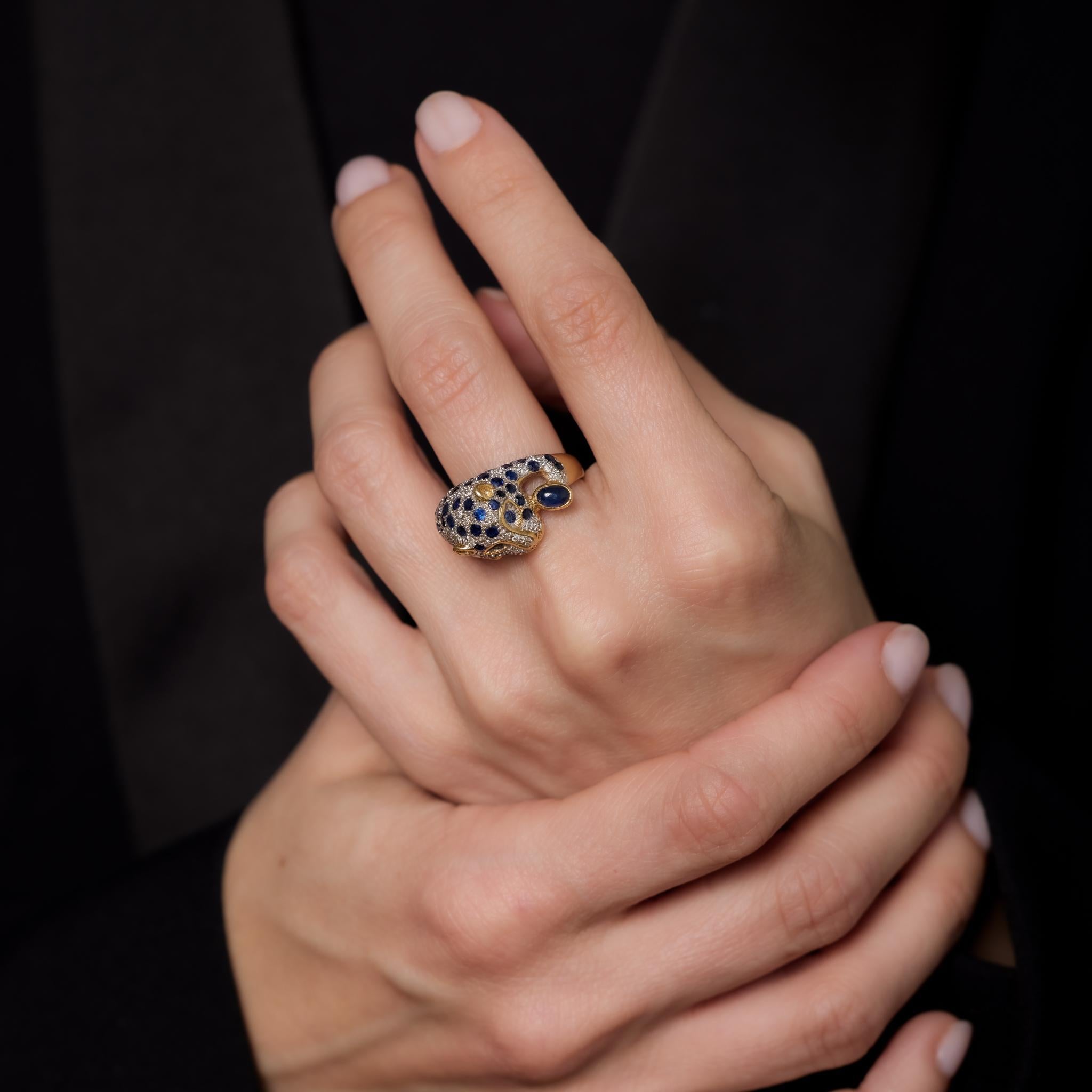 This vintage French panther ring showcases one cabochon cut and 49 round cut sapphires totaling 2.80 carats, accented by 28 round brilliant cut diamonds weighing .15 carats, H-I color, and VS-SI clarity. Crafted in 18k yellow gold with a white gold