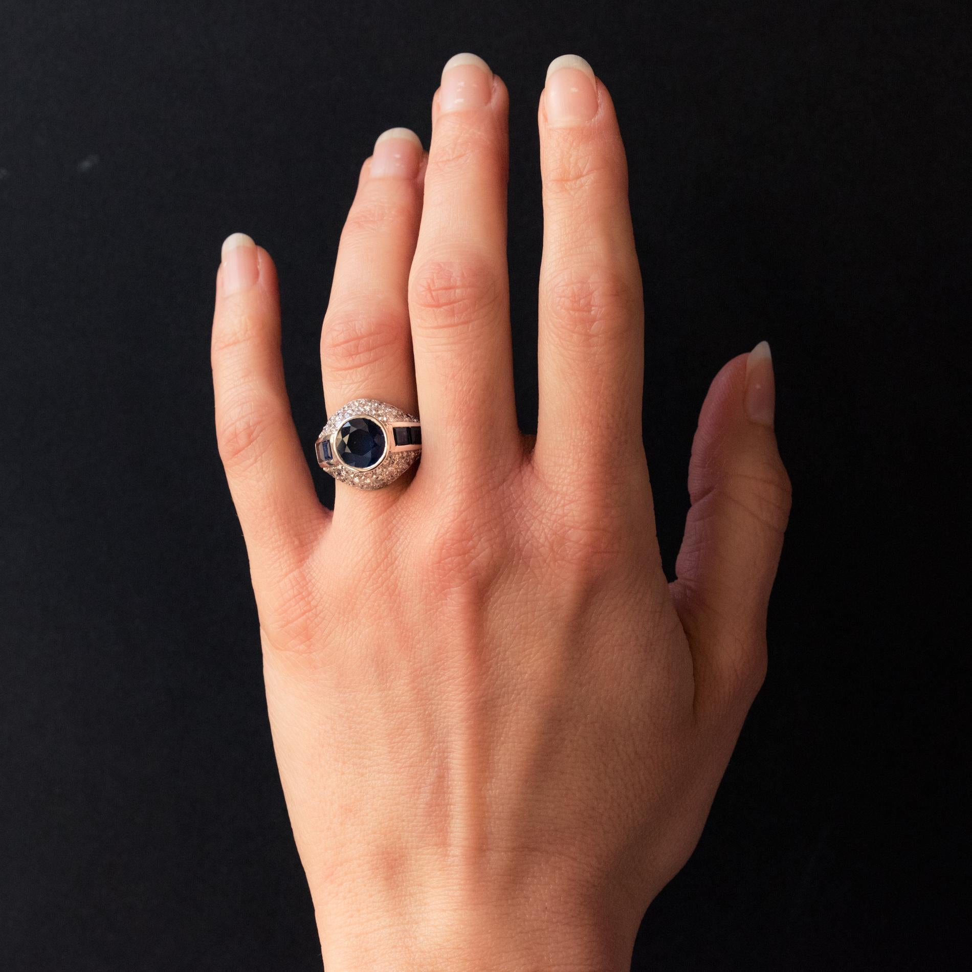 Ring in Platinium and 18 carat yellow gold, dog and eagle heads hallmarks. 

This splendid sapphire and diamond dome style ring features a good sized bezel set round sapphire of a deep blue. This is accentuated by 2 square sapphires at each side,