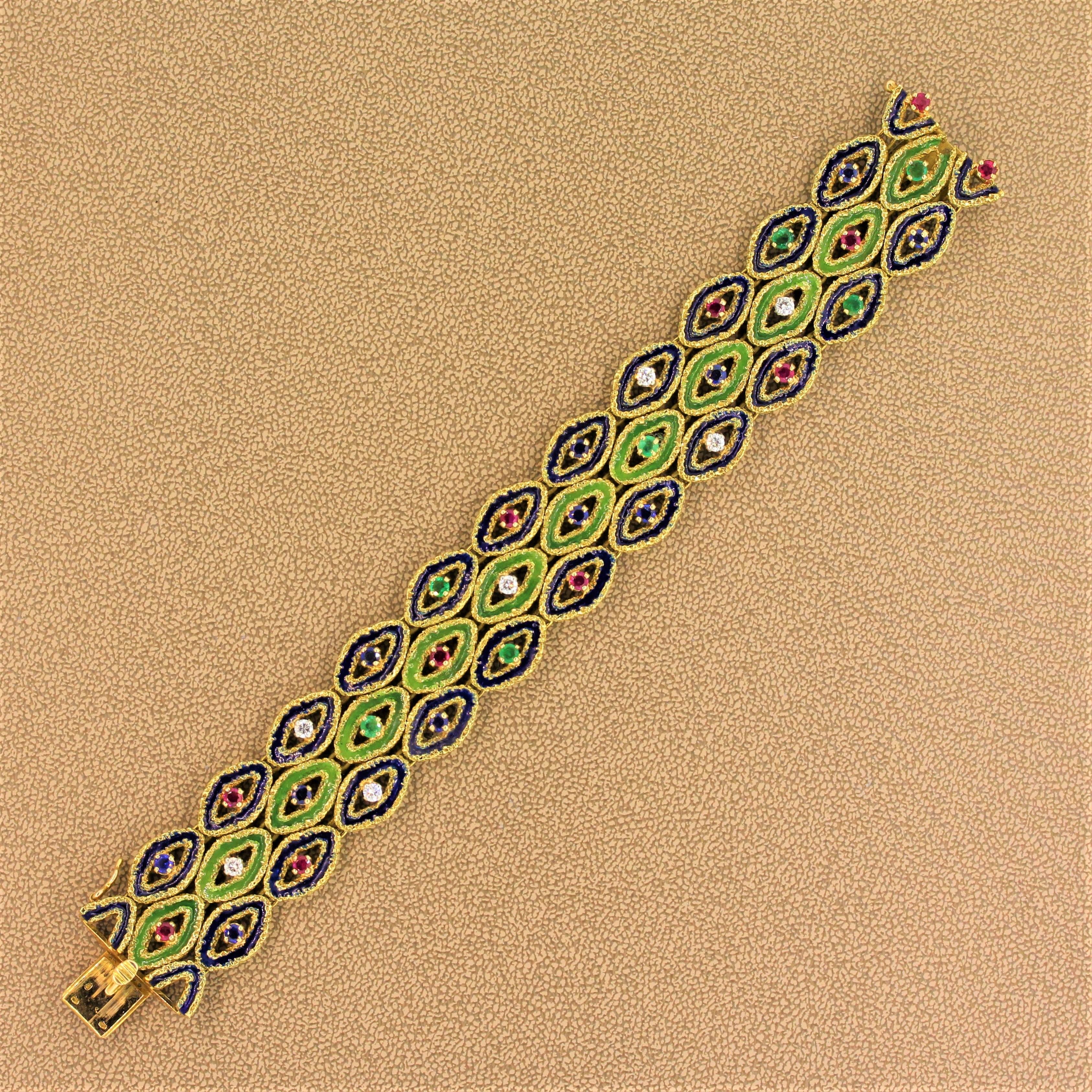 A beautiful French bracelet featuring fine sapphire, ruby and emeralds as well as diamonds in an 18K yellow gold setting. Each precious stone is prong set in the center of rows of hand painted blue and green enamel with a textured filigreed gold