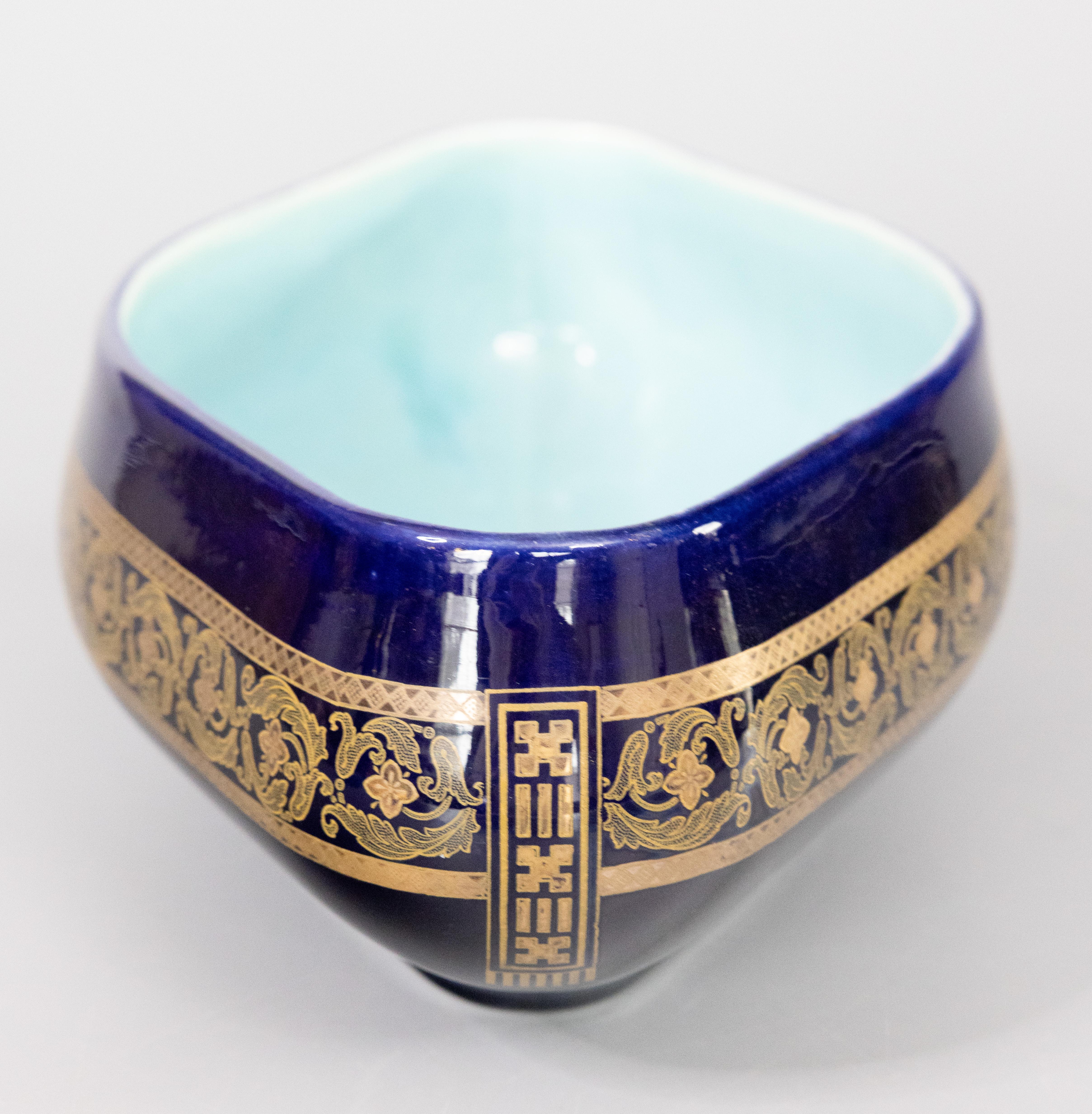 A gorgeous antique Neoclassical style French Sarreguemines cobalt blue majolica oval centerpiece bowl, circa 1900. Maker's mark on reverse. This stylish chic bowl is decorated with gold gilt laurel wreaths and foliate designs on a rich dark cobalt