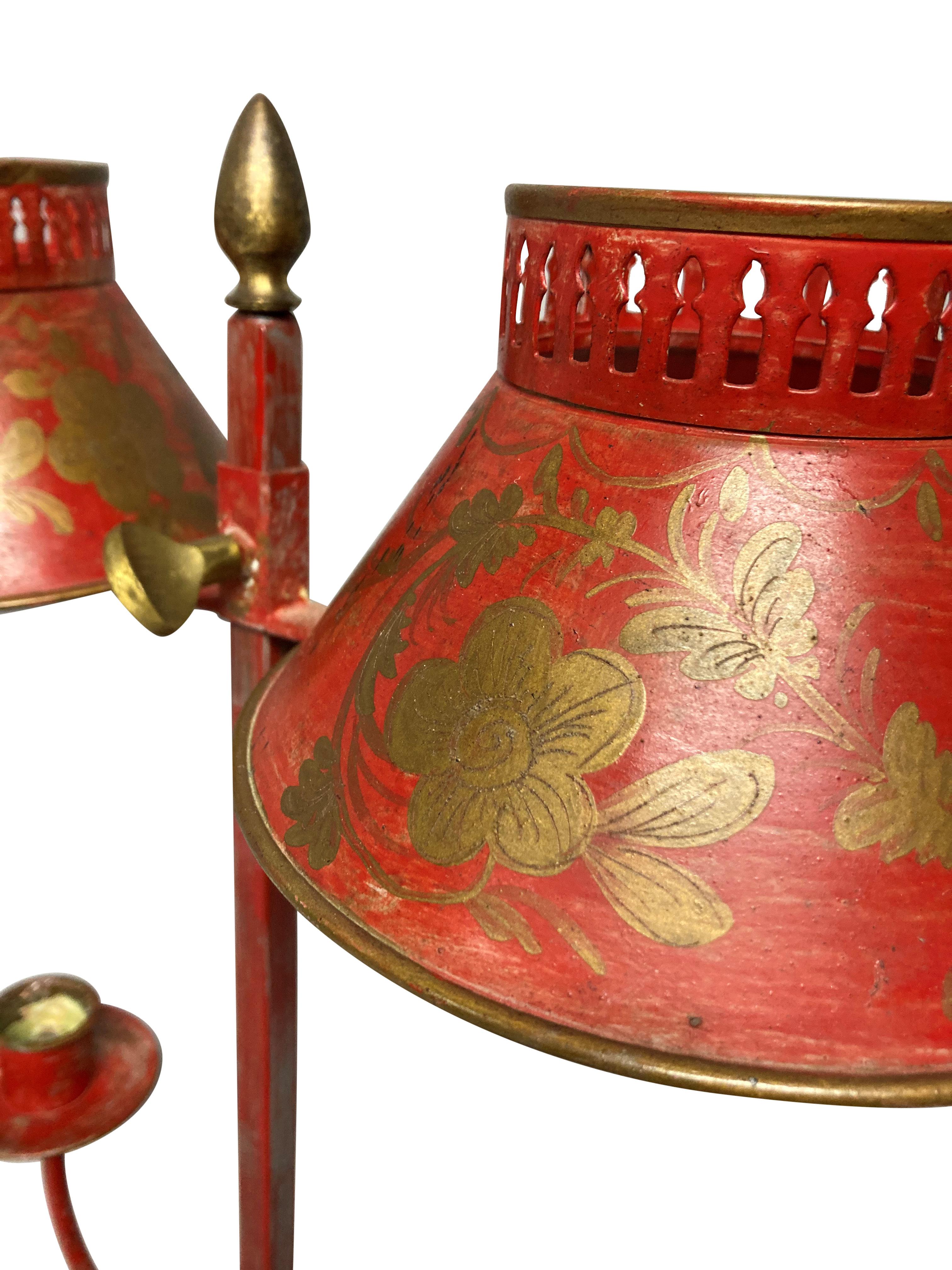 A French scarlet and gilt decorated tole desk lamp, with two arms and adjustable shades. For candles.