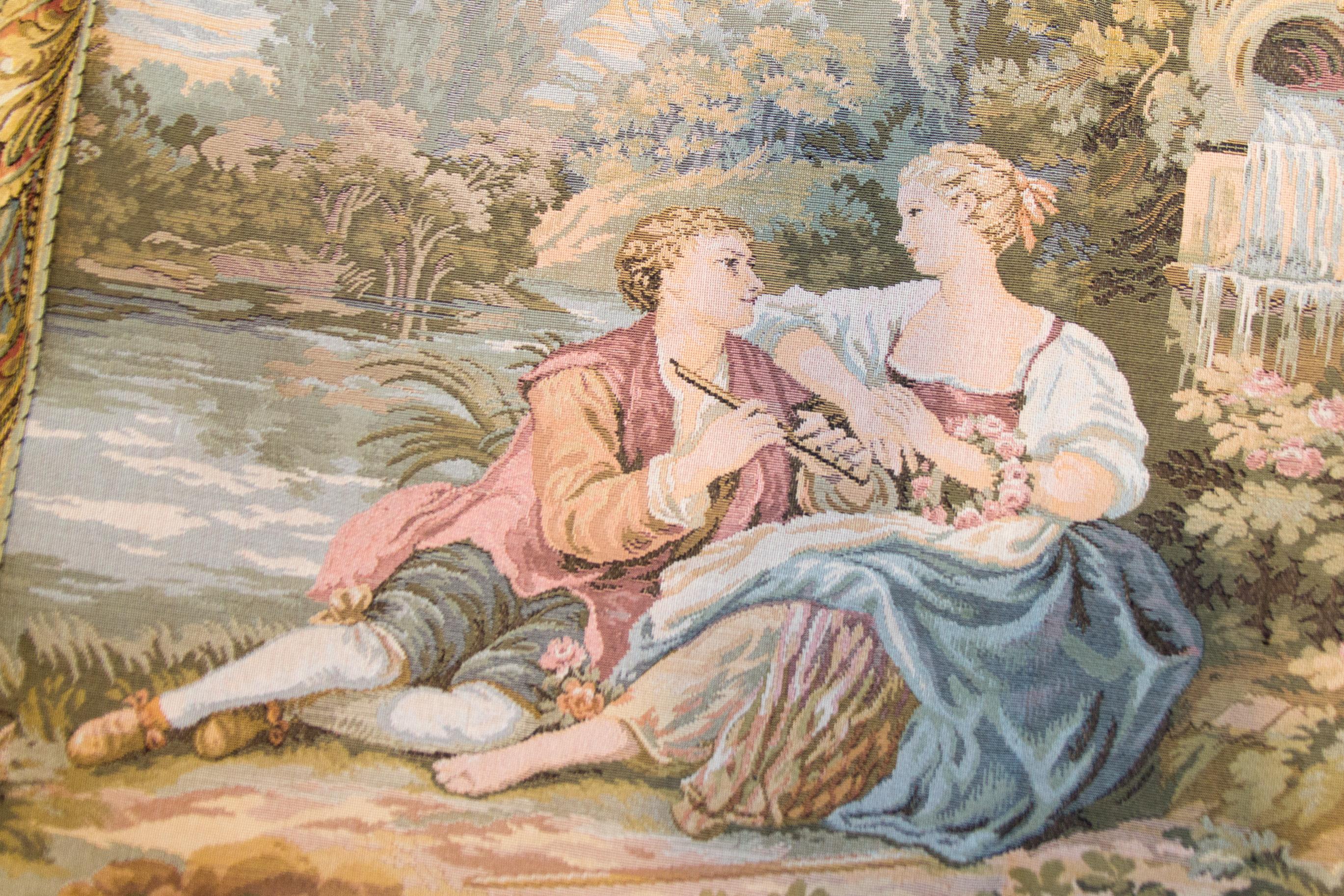 This vintage scenic tapestry shows courting couples in an idyllic country setting by a lake and a cherub statue, waterfall. It is made in a soft, light color palette of greens, pinks, and blues.
Tapestry is lined on the back and comes with a tunnel