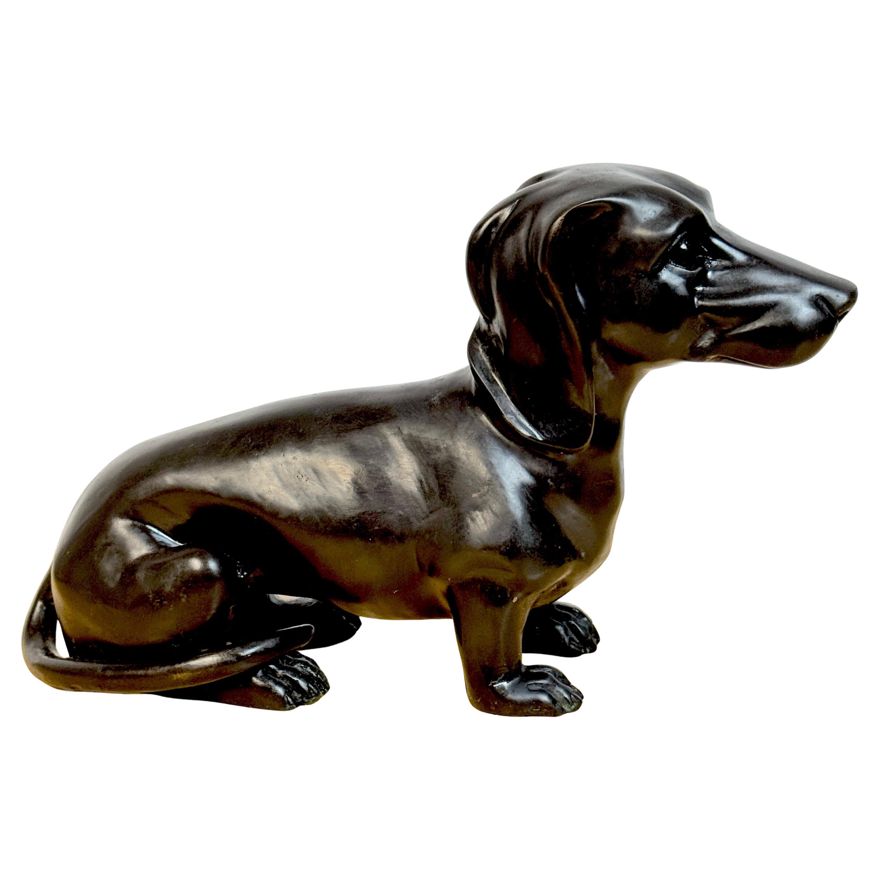 Bronce patinado de la escuela francesa de un perro salchicha descansando en venta