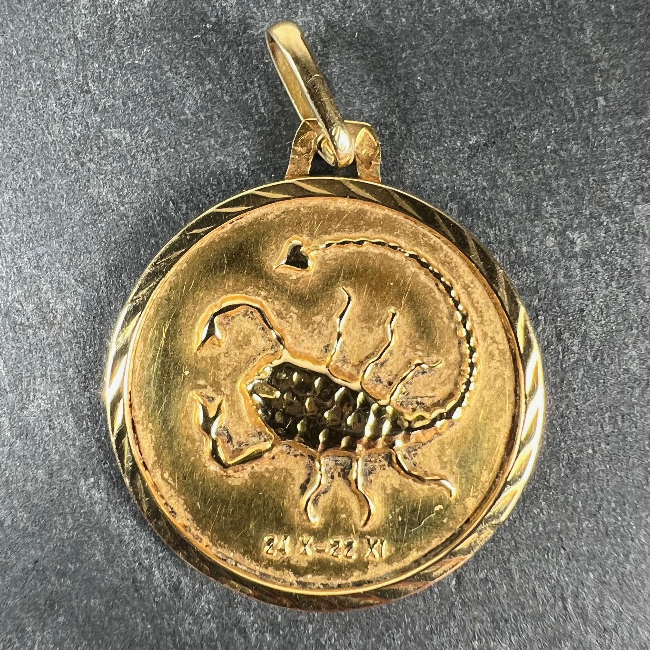 A French 18 karat (18K) yellow gold charm pendant designed as a round medal depicting a scorpion in relief with the date range 24 X - 22 XI beneath it, representing the zodiac star sign of Scorpio. Stamped with the eagle's head for 18 karat gold and