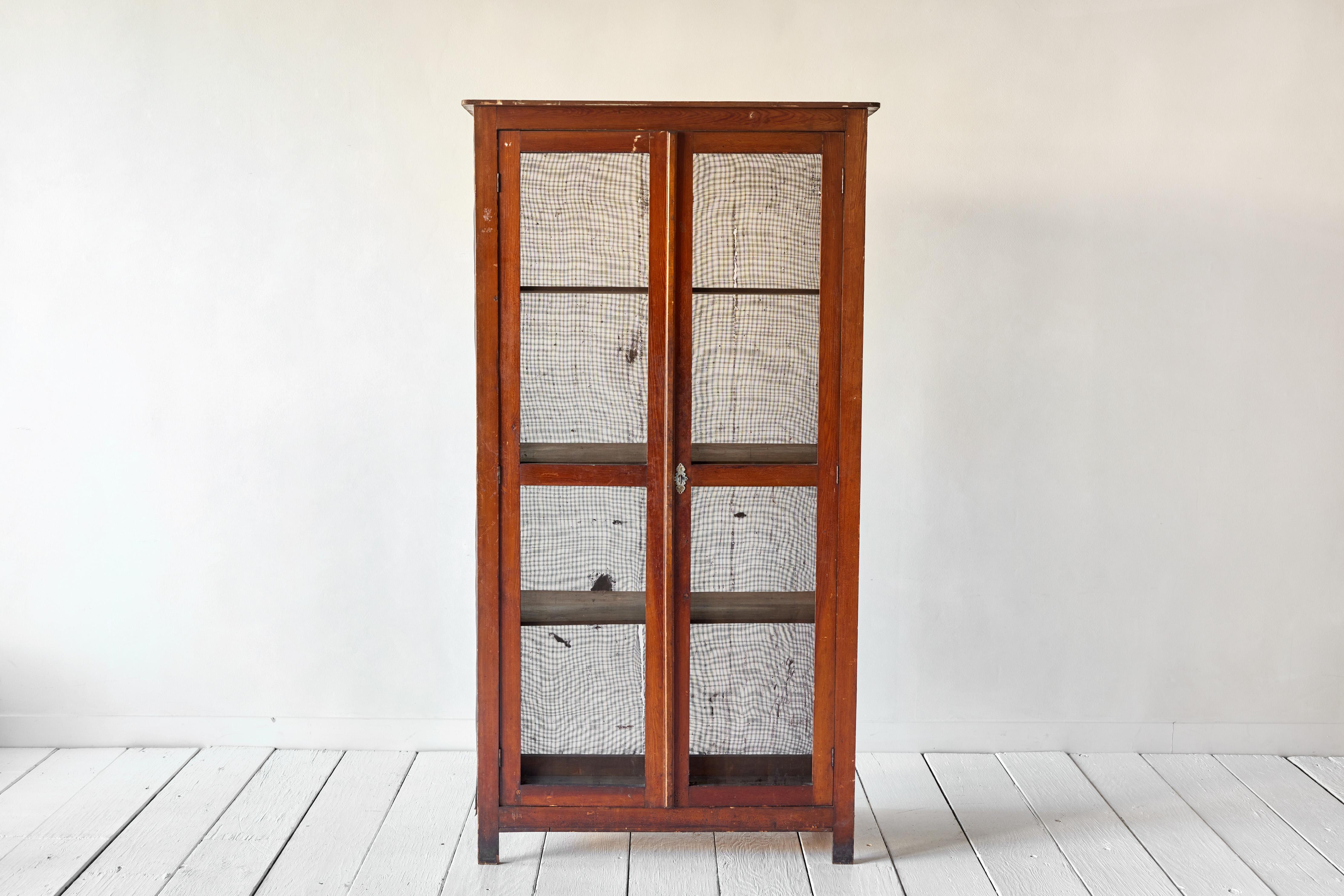 Rustic French screened cabinet from the early 20th century that was once used for food storage. The metal screen is worn and has a tear in the back. Three interior shelves provide ample storage.