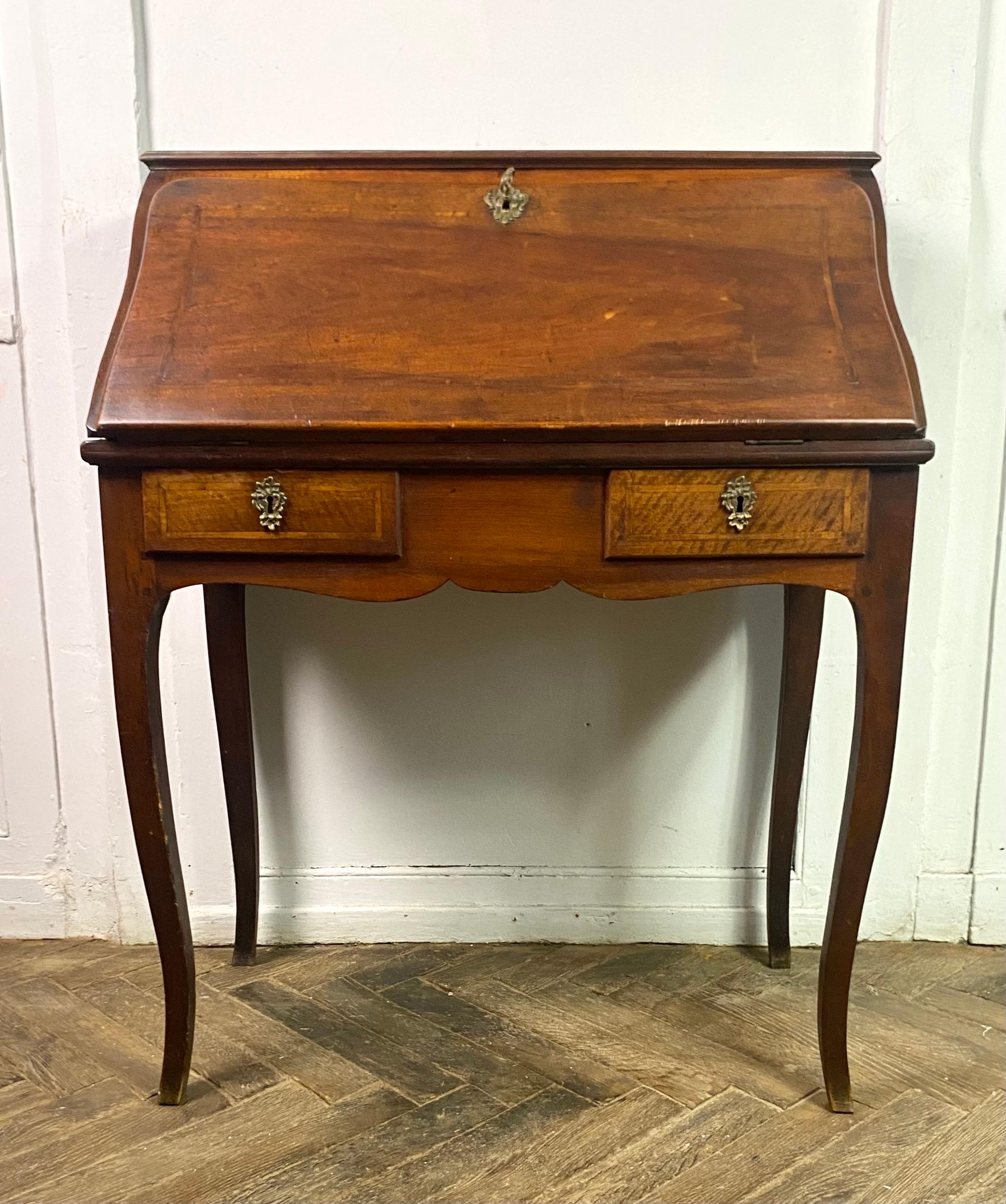 Magnificent donkey back desk, sloping desk from the Louis XV period from the 18th century. It opens with a flap which reveals 4 interior drawers, 1 shelf and 2 lockers as well as a small secret compartment on the double bottom.
This pretty desk
