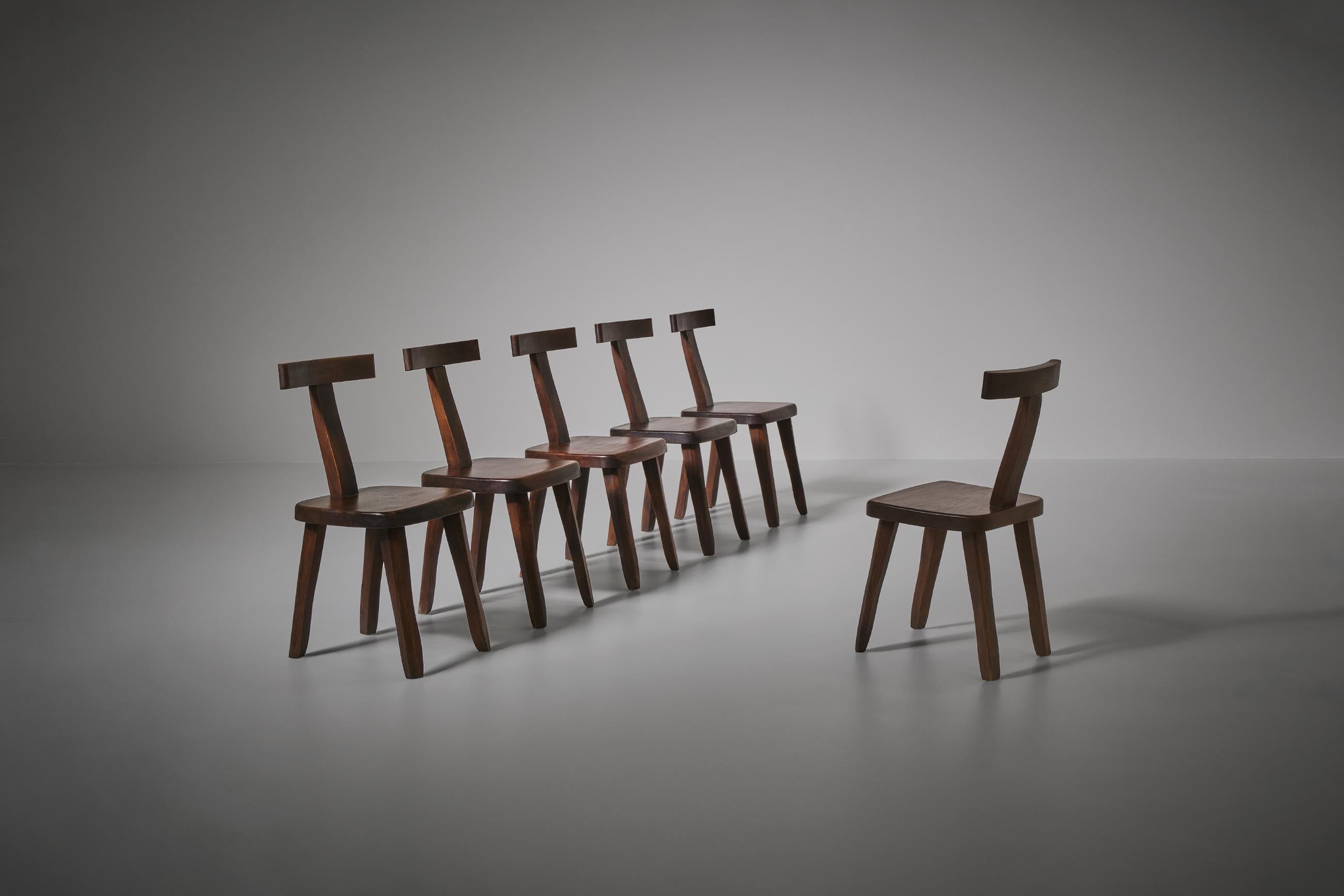 Set of six sculptural side chairs often attributed to Olavi Hänninen but actually a French production of the 60s. The chairs are constructed out of dark stained Elm wood with nice warm tones. Every single element of the chairs is carved by hand,