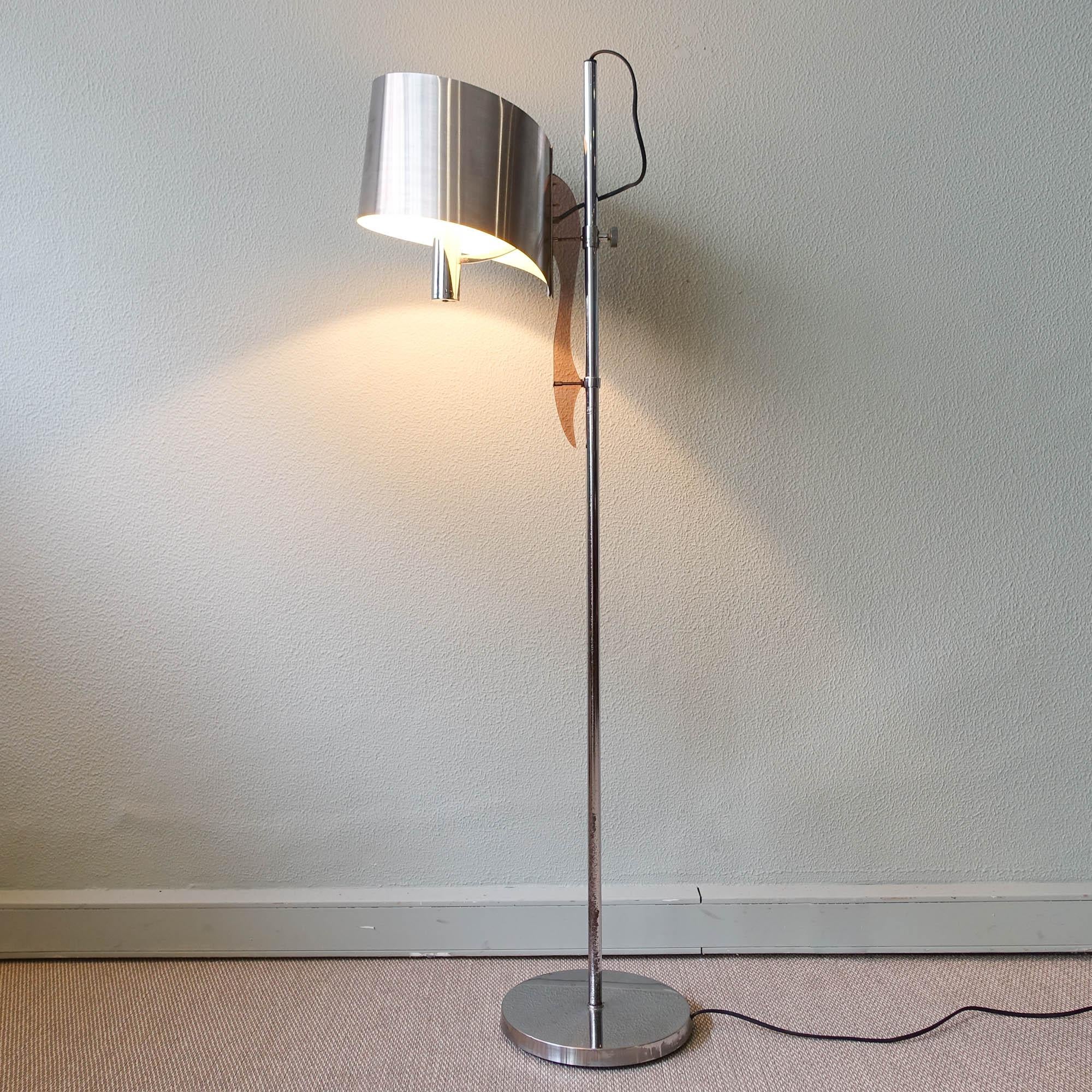 This floor lamp, model 'Ruban' (ribbon), was designed by Jacques Charles around 1965. Just like many other Charles designs from that period it’s shade is made out of folded metal, which gives the lamp a sculptural appearance. The ribbon shaped shade