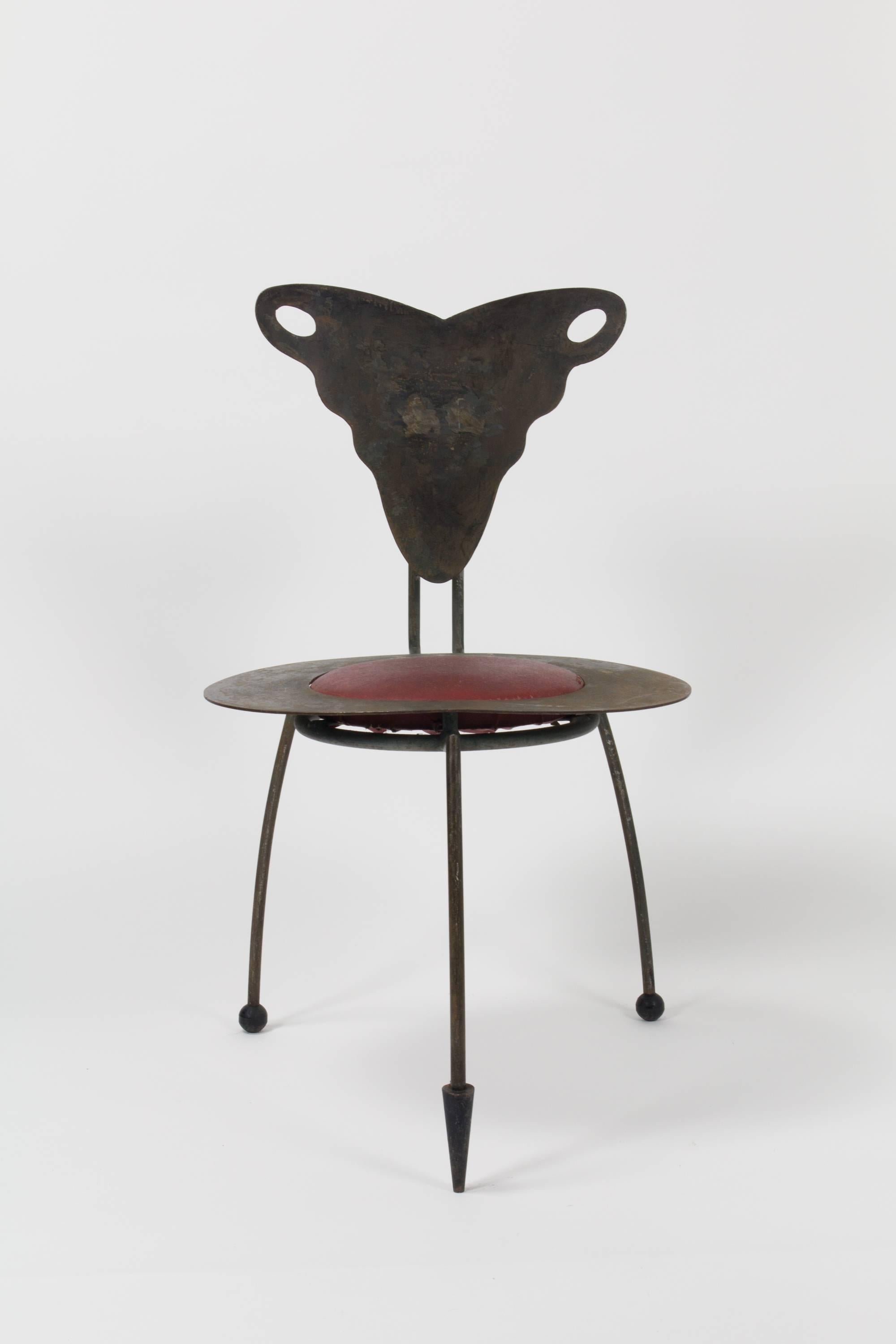 Anonymous three-legged sculptural art-chair with praying mantis motif, comprised of hand cut and welded steel elements and floating seat cushion in maroon vinyl upholstery.