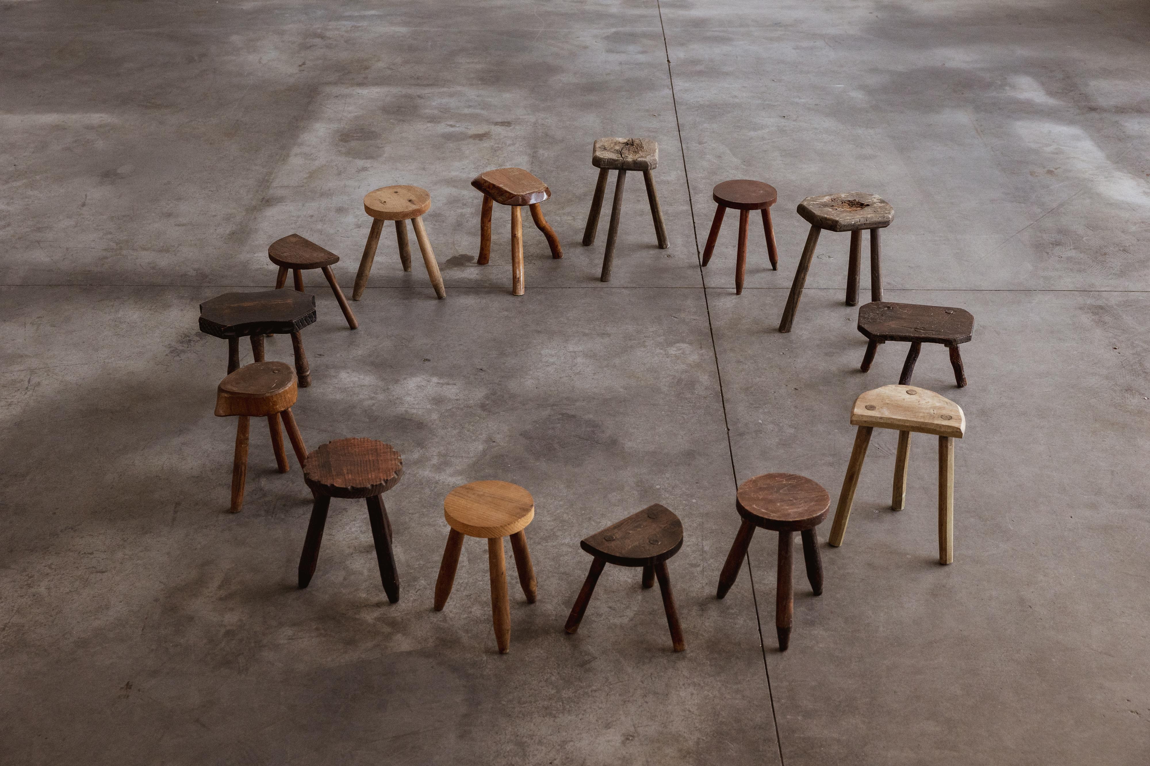 French Sculptural Primitive Stools, wood, 1960, set of fourteen.

This collection of hand-carved stools originates from rural France, dating from the 1960s. Each piece is a microcosm of functional imperfection: uneven seat planes, worn edges, and