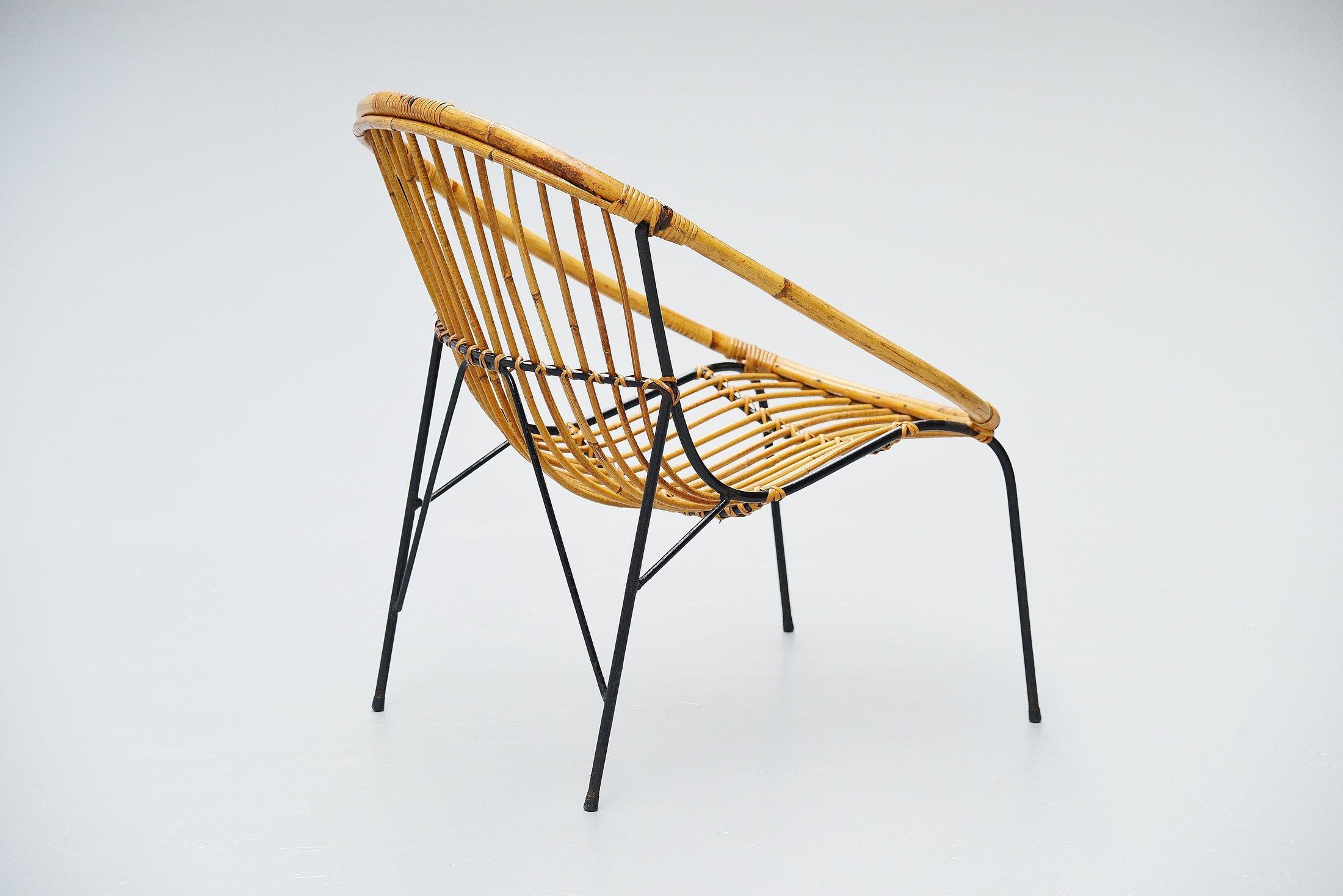 Very nice sculptural rattan small lounge chair made by unknown designer or manufacturer in France, 1950. The chair has a solid steel frame, black painted and rattan handwoven seat. Very nicely shaped chair, can be finished with a sheep skin for