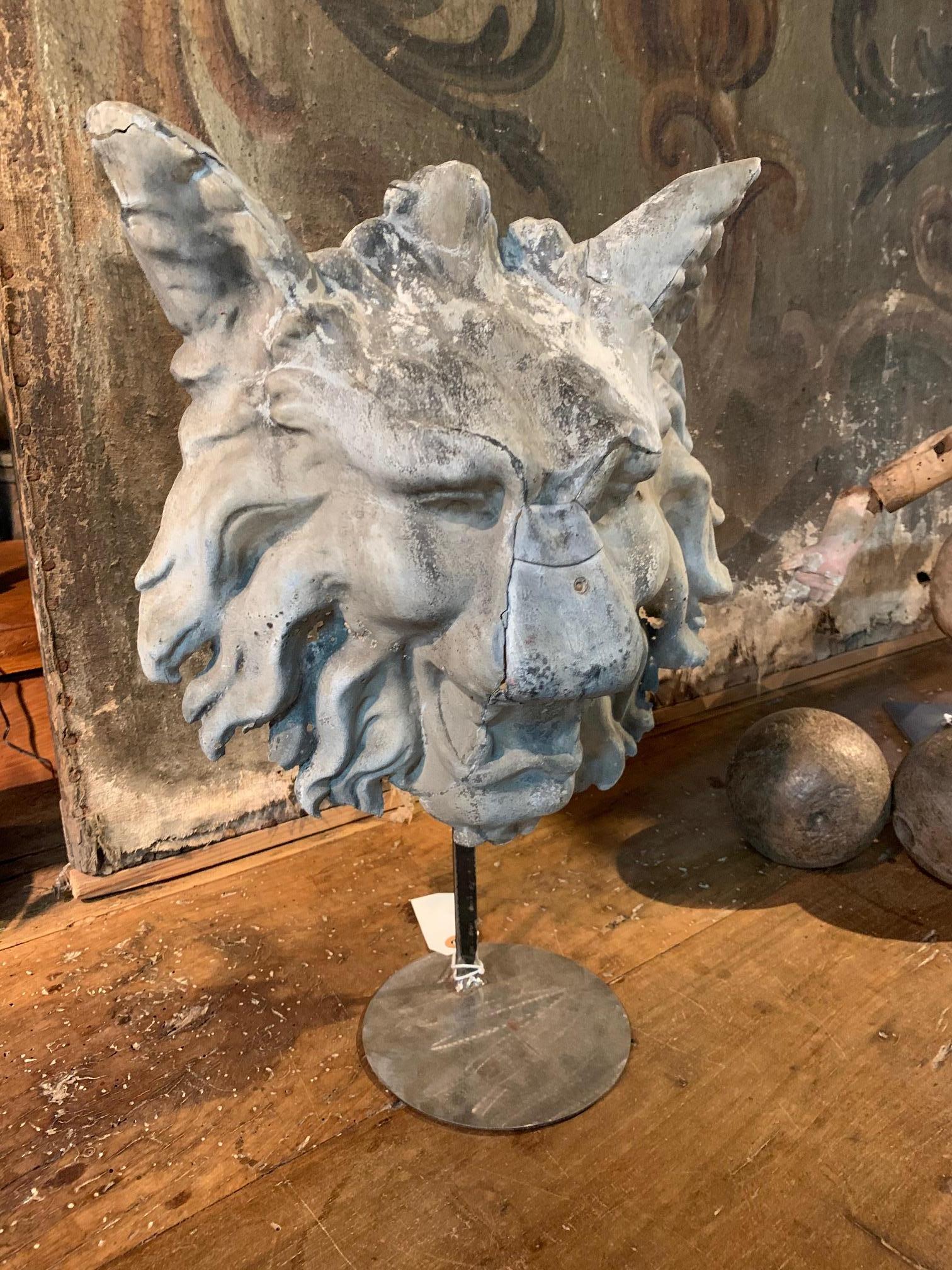 A terrific mask in zinc of the head of a mythical lion-wolf presented on its metal stand, early 18th century from France. A fabulous accent piece for any living area.