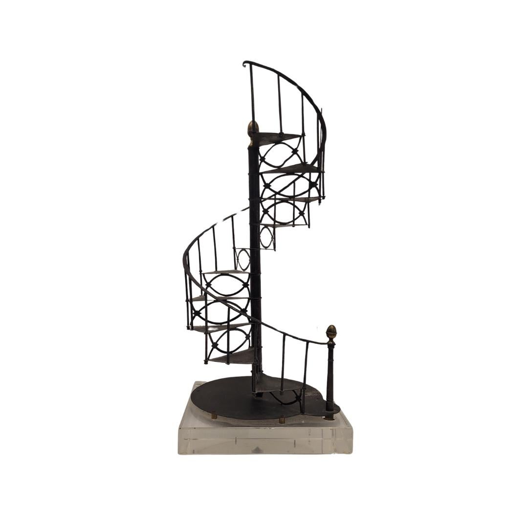 Eccezionale modello di scala realizzato in ferro battuto, intorno al 1950, in Francia. Questa scala a chiocciola è strutturata a spirale intorno a un asse centrale o palo chiamato nucleo. È stato realizzato in ferro battuto, con due ornamenti in