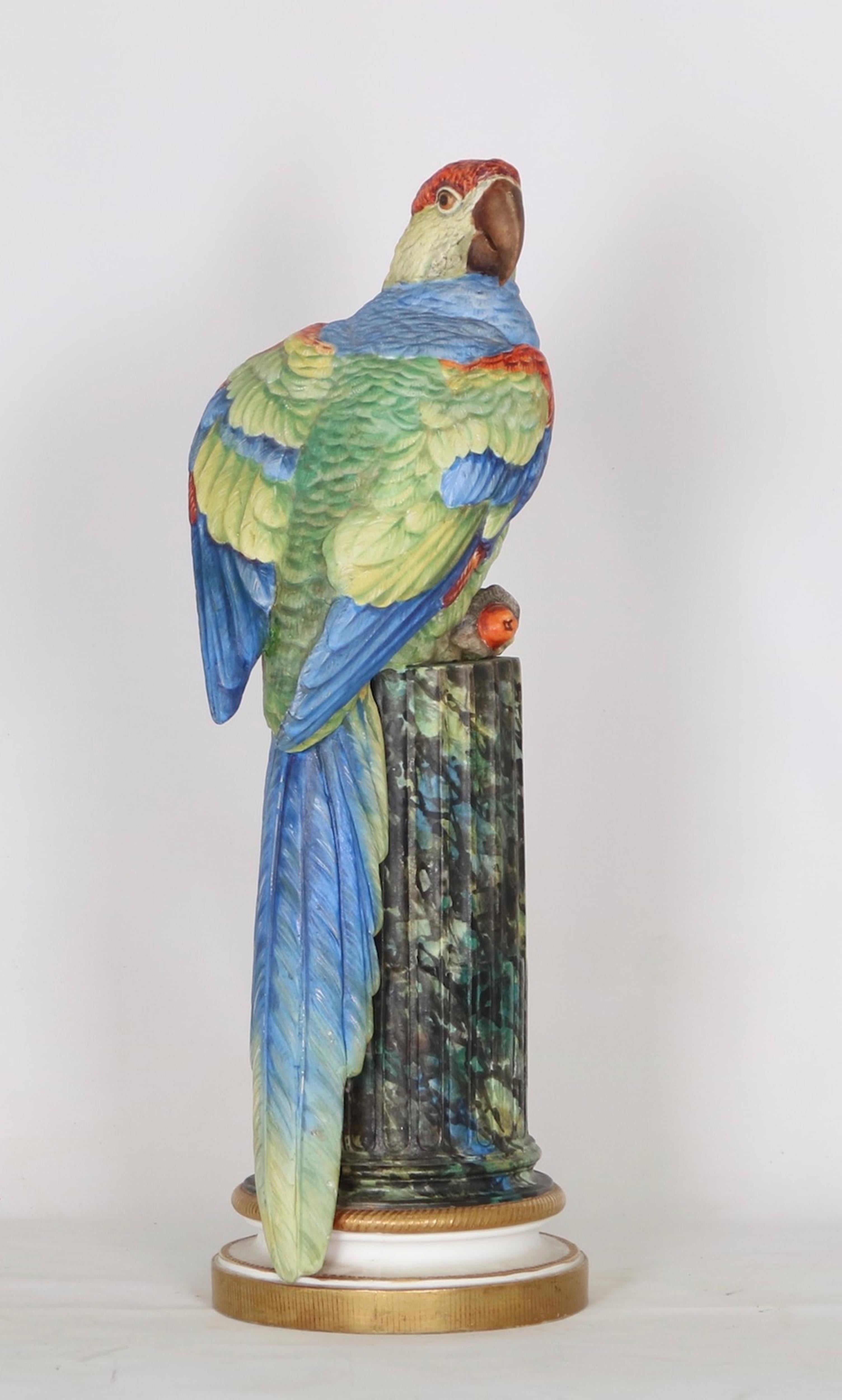 French Bisque sculpture of a parrot from the late 19th century. Features include a brightly painted parrot on a ribbed column base with gold-tone accents. The piece includes a blue seal on the interior. Wear appropriate to age and use. The sculpture